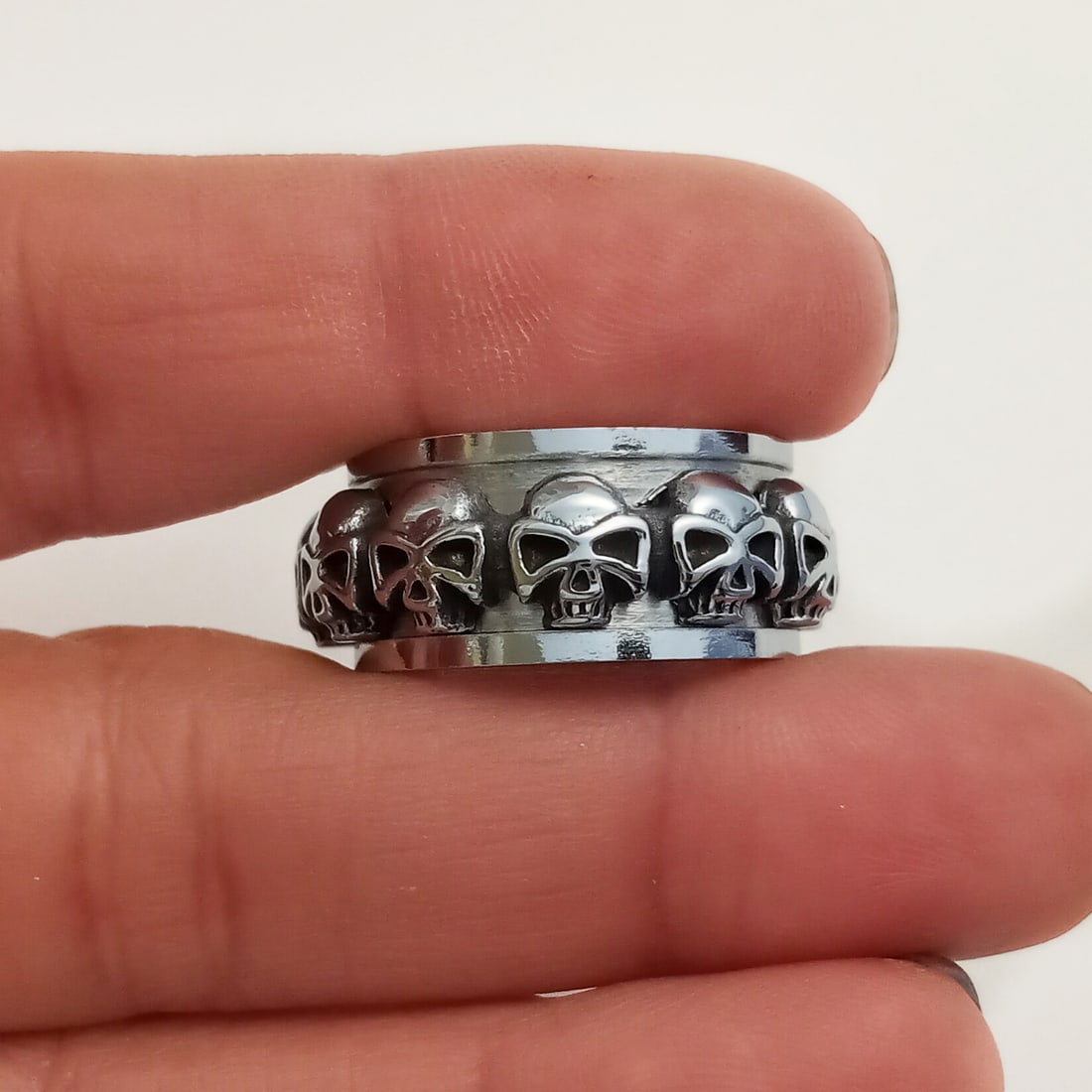 Stainless steel skulls design spinner band ring, size 9: Stainless steel with blackened details skulls design spinner band ring, size 9. Band width measured approximately 3/8 inches. Condition excellent.