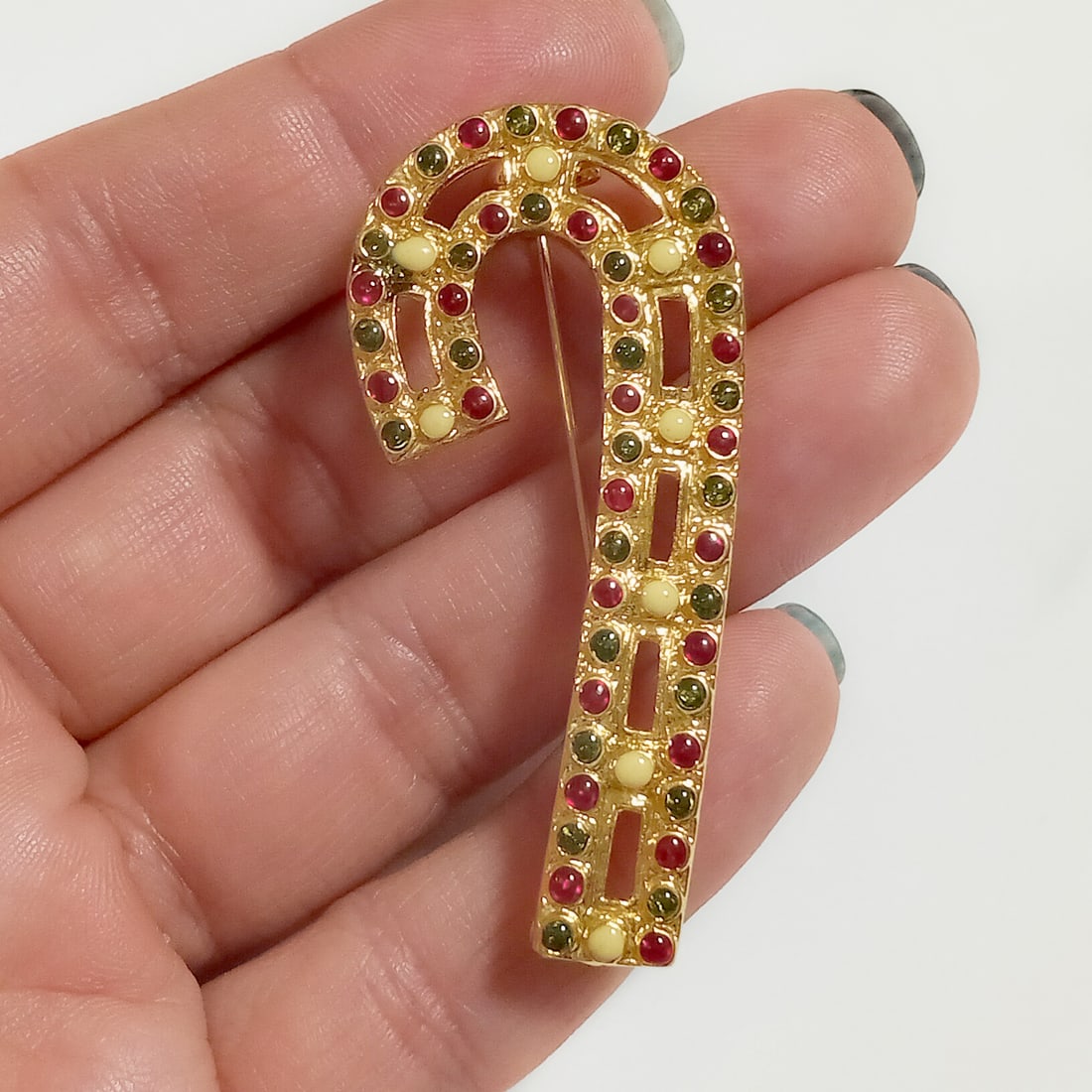 Vintage gold tone enamel candy cane brooch: Vintage gold tone red, green and white enamel candy cane brooch. Measured 2 x 1 inches. Condition very good.