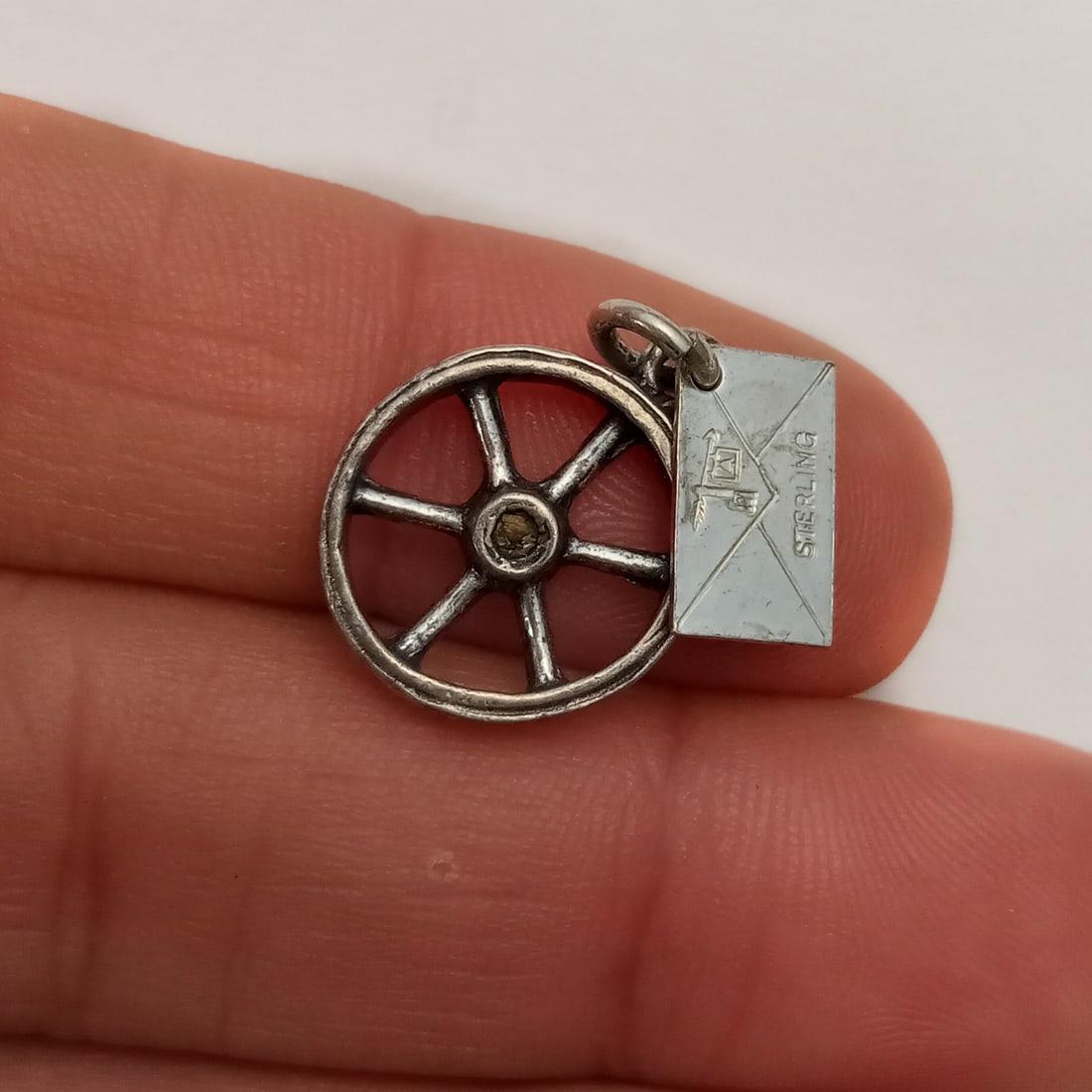 Vintage sterling silver Cave of the Winds wheel charm: Vintage sterling silver Cave of the Winds wheel charm. Weight 1.95 grams. Length 3/4 inches with bail. Hallmarked Sterling. Condition very good.