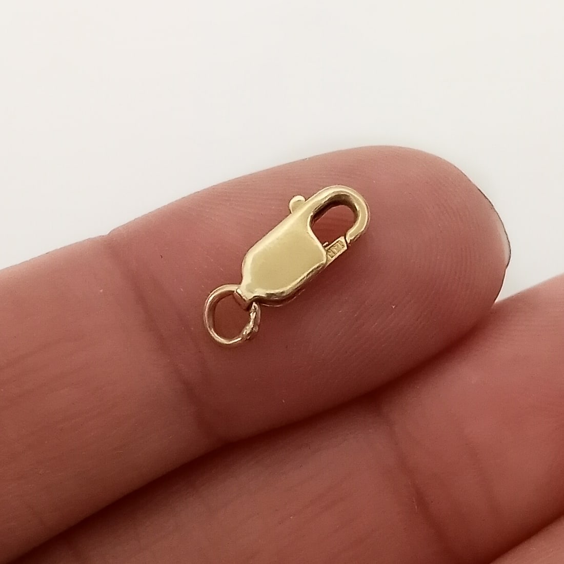 14K Yellow gold lobster clasp: 14K Yellow gold lobster clasp for bracelet, chain or necklace. Weight 0.50 grams. Length 10.1 mm without the loop. Hallmarked 14K. Condition very good.