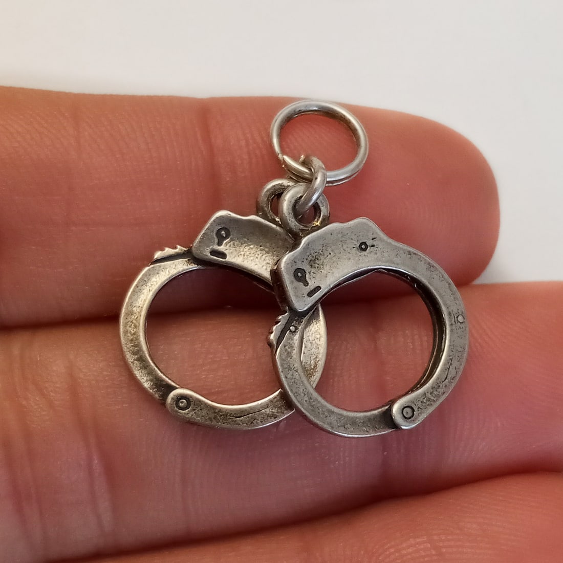 Vintage sterling silver Handcuffs charm: Vintage sterling silver Handcuffs charm. Weight 3.21 grams. Length 1 inch with bail. Hallmarked 925. Condition very good.
