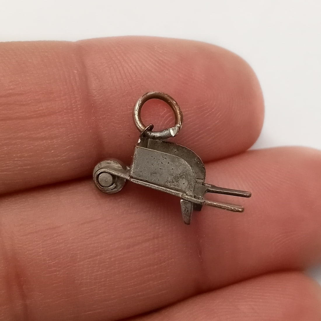 Vintage sterling silver wheelbarrow charm: Vintage sterling silver wheelbarrow charm with moving wheel. Weight 0.68 grams. Length 1/2 inches with bail. No hallmark, tested 925. Condition very good.