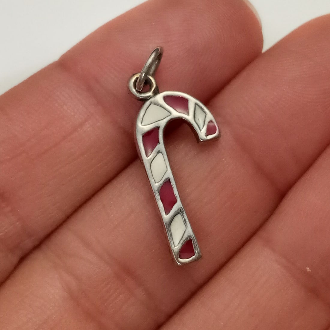 Vintage sterling silver enamel Candy Cane charm: Vintage sterling silver red and white enamel Candy Cane charm pendant. Weight 1.62 grams. Length 1 inch with bail. Hallmarked 925, maker's logo. Condition very good.