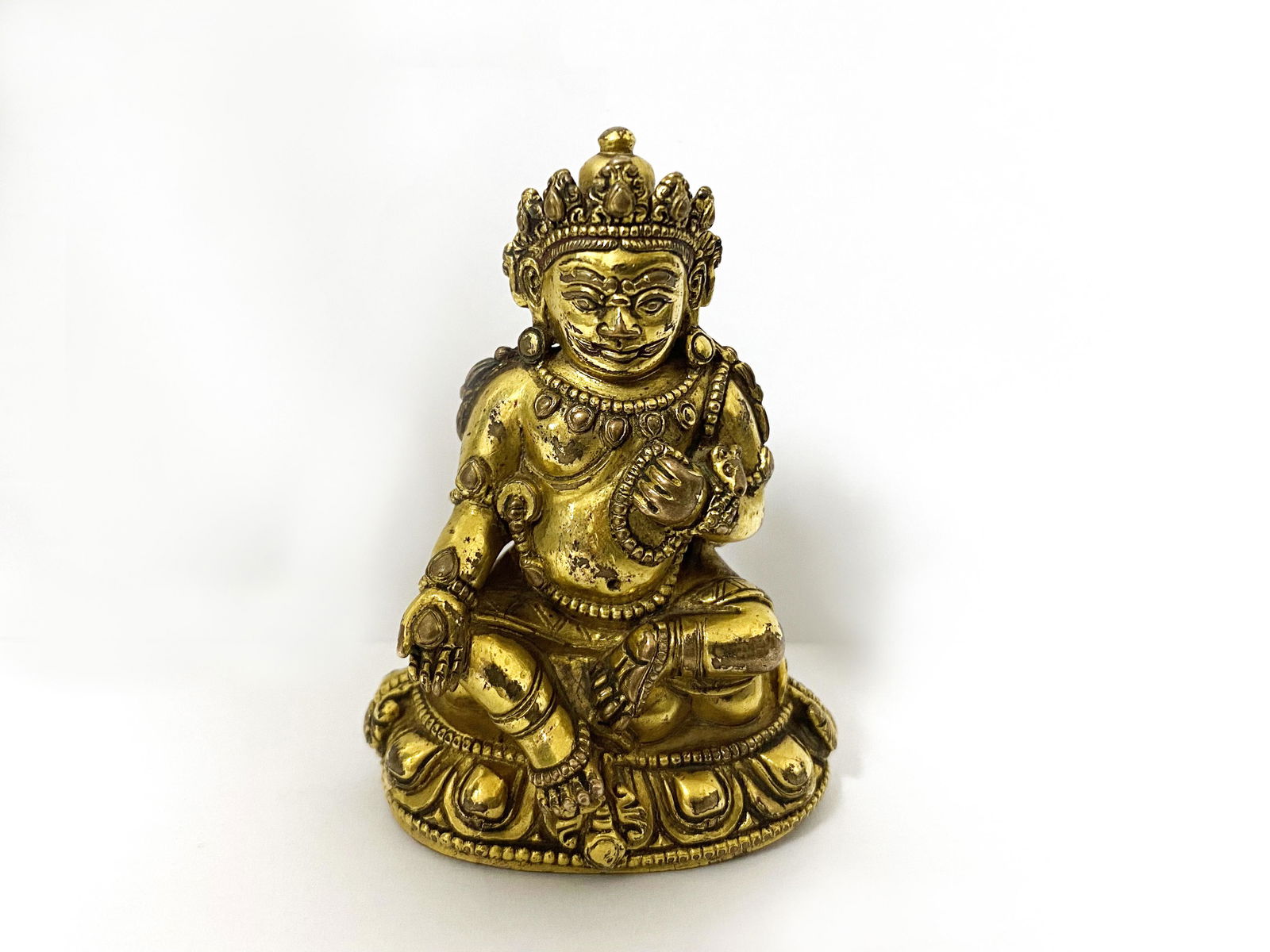 A GILT BRONZE FIGURE OF A JAMBHALA (1 of 3)