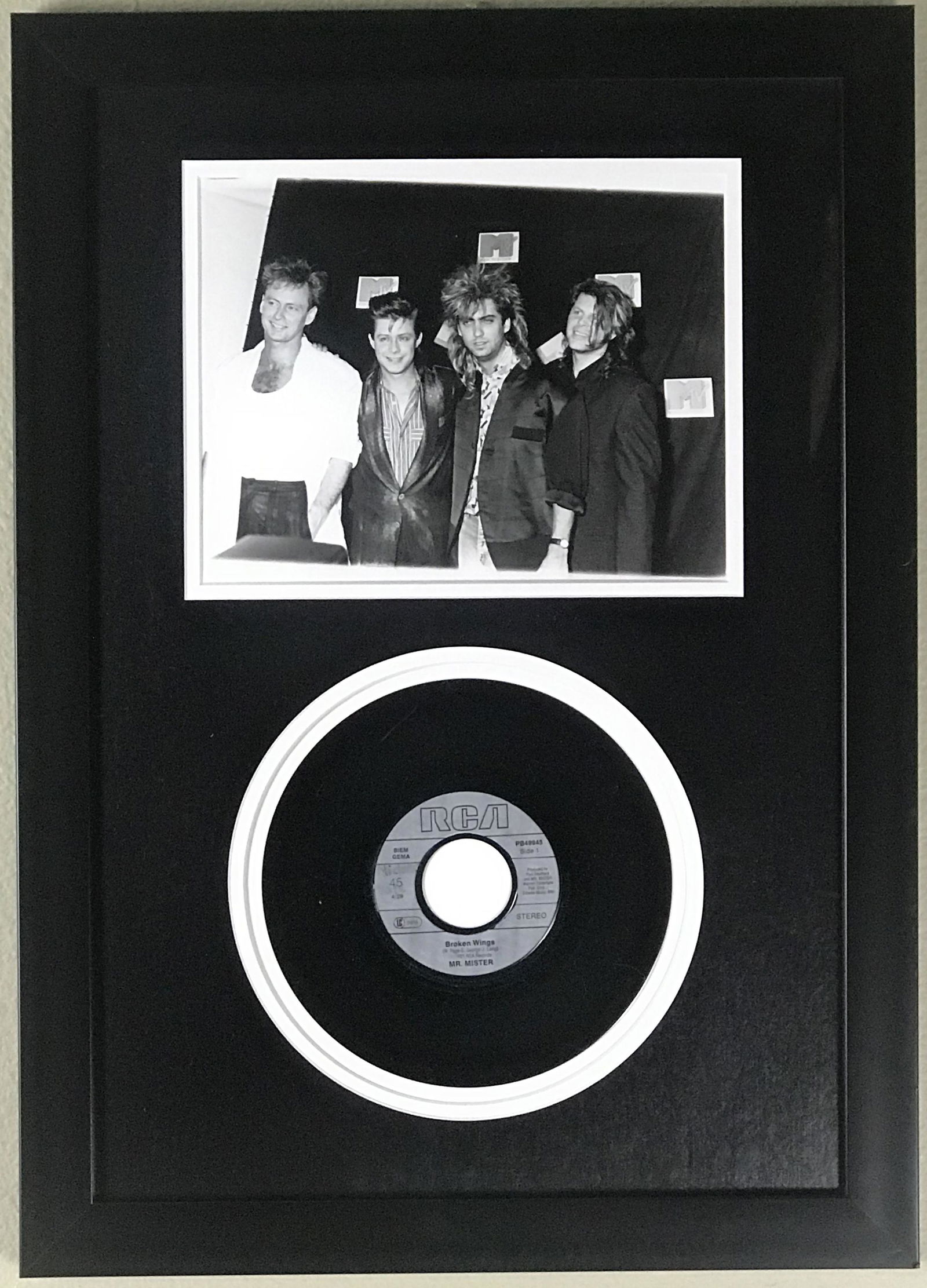 Mr. Mister "Broken Wings" Collage: Fun piece for any Mr. Mister fan! Collage features a great press photo of the band from the 1986 MTV Music Video Awards and a copy of their most popular hit "Broken Wings". Features: Great blac