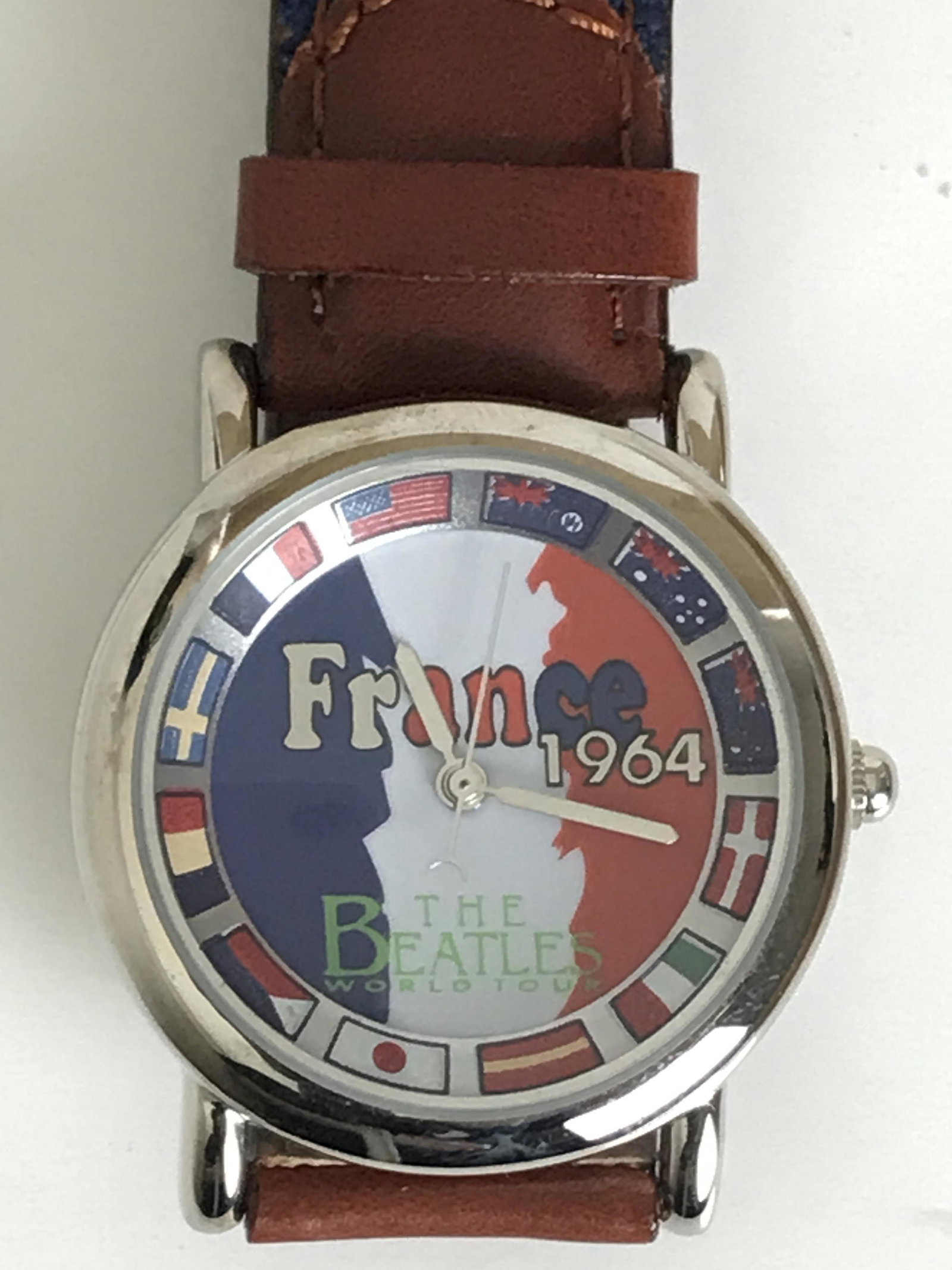 Beatles Licensed "France 1964" Watch - New: Officially licensed Beatles watch with "France 1964" face and brown/navy band. Comes in real wood guitar-shaped case and original packaging as shown in photos. Unisex watch but note bez