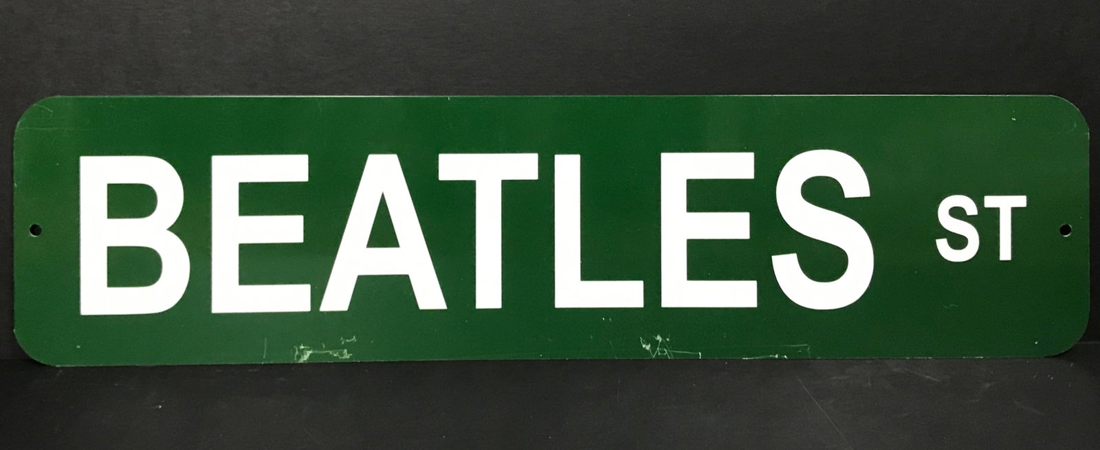 Beatles St Metal Street Sign: Green metal "Beatles St" street style sign. Measures approx. 24" wide x 6" high, this is a good quality, and quite heavy, metal sign. Features: Green metal "Beatles St" street style sign Mea