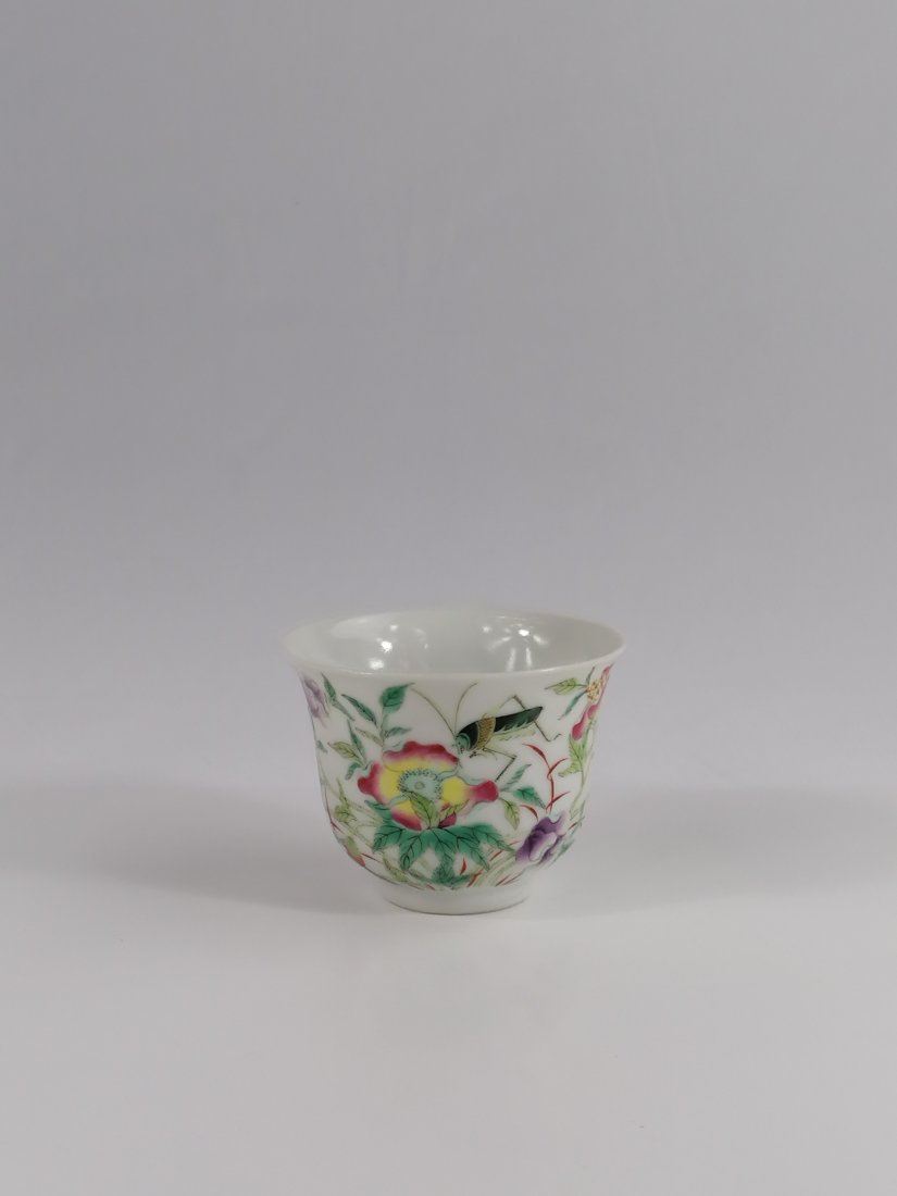 A Chinese famille rose cup: 19th century, Qing dynasty, Guangxu mark and period. The cup is decorated to the exterior with peony blossoms growing beside a rocky bed and a small butterfly flying amongst them and a cricket rest on