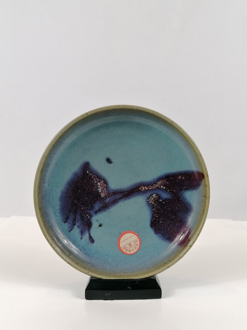 A Jun Ware sky-blue glazed brush washer: Yuan/Ming dynasty, toneware. Jun ware shallow bowl on short foot covered with sky blue glaze, flame-red appeared inside the brush washer. Draining to a mushroom tone at the rim, the glaze pooling unev