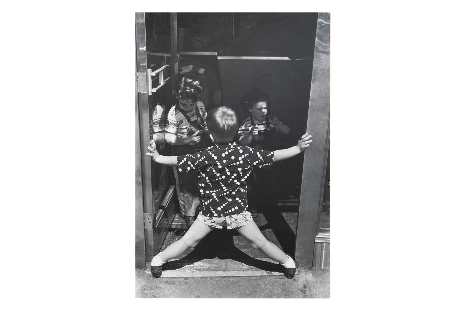 Louis Stettner, American 1922-2016, In a Doorway, 3rd Avenue, Photograph: Louis Stettner American, 1922-2016 In a Doorway, 3rd Avenue Photograph Approximate Page size: 20" H x 14" W Approximate Image size: 18.75" H x 12.5" W Approximate Frame size: 25.75" H x 19.5" W F