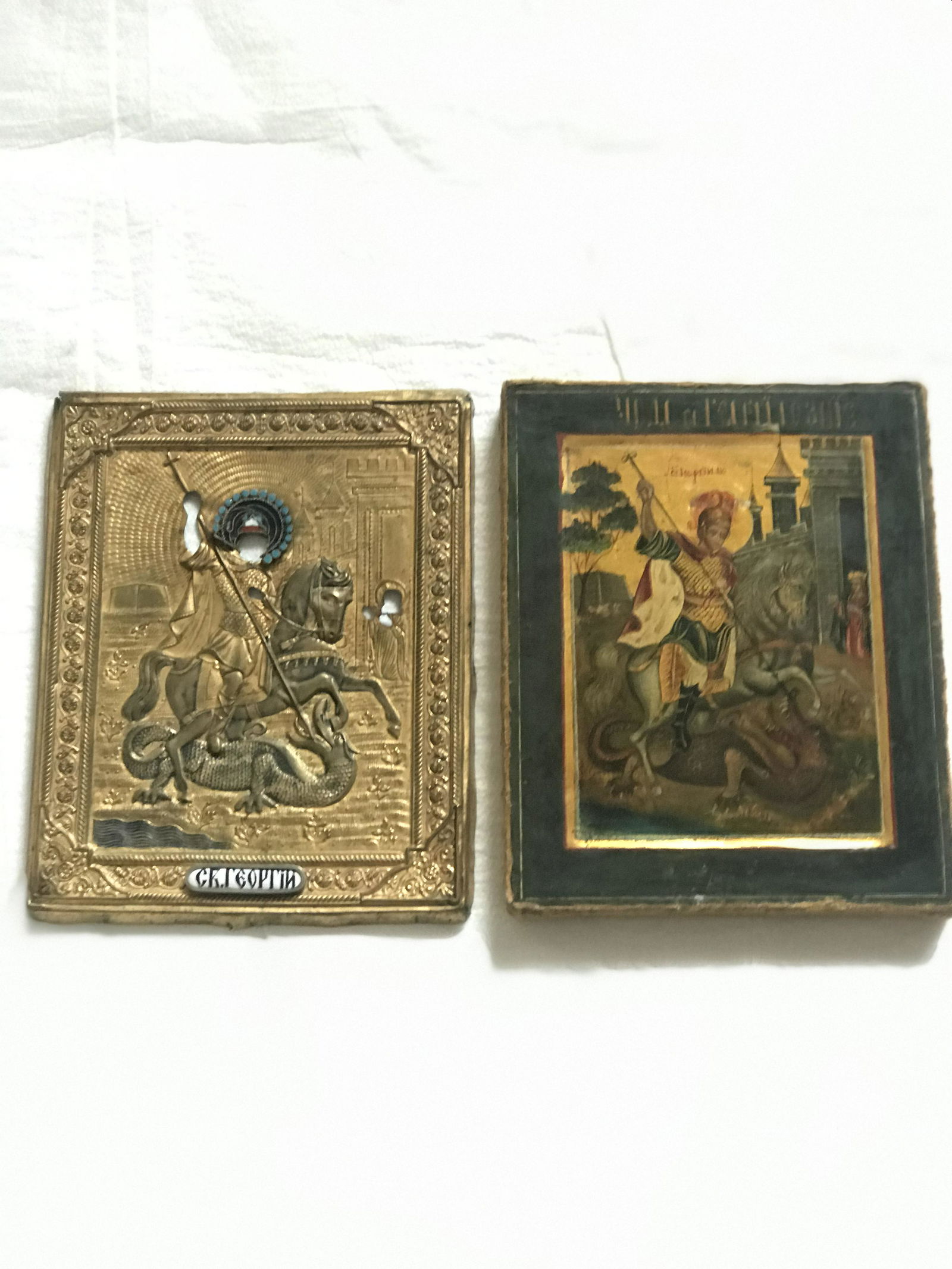 Rare Russian Antique Icon of Saint George Sleighing the Dragon: St George conquering the dragon in brass embossed oklad with blue enamel accents.