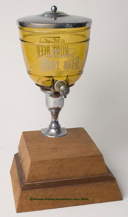 FOWLER'S ROOT BEER GLASS DISPENSER, amber, metal: FOWLER'S ROOT BEER GLASS DISPENSER, amber, metal lid, faucet and pedestal with clamp, mounted to a modern wooden base, pedestal with Fowler property stamp. Size: 17 1/2" h overall