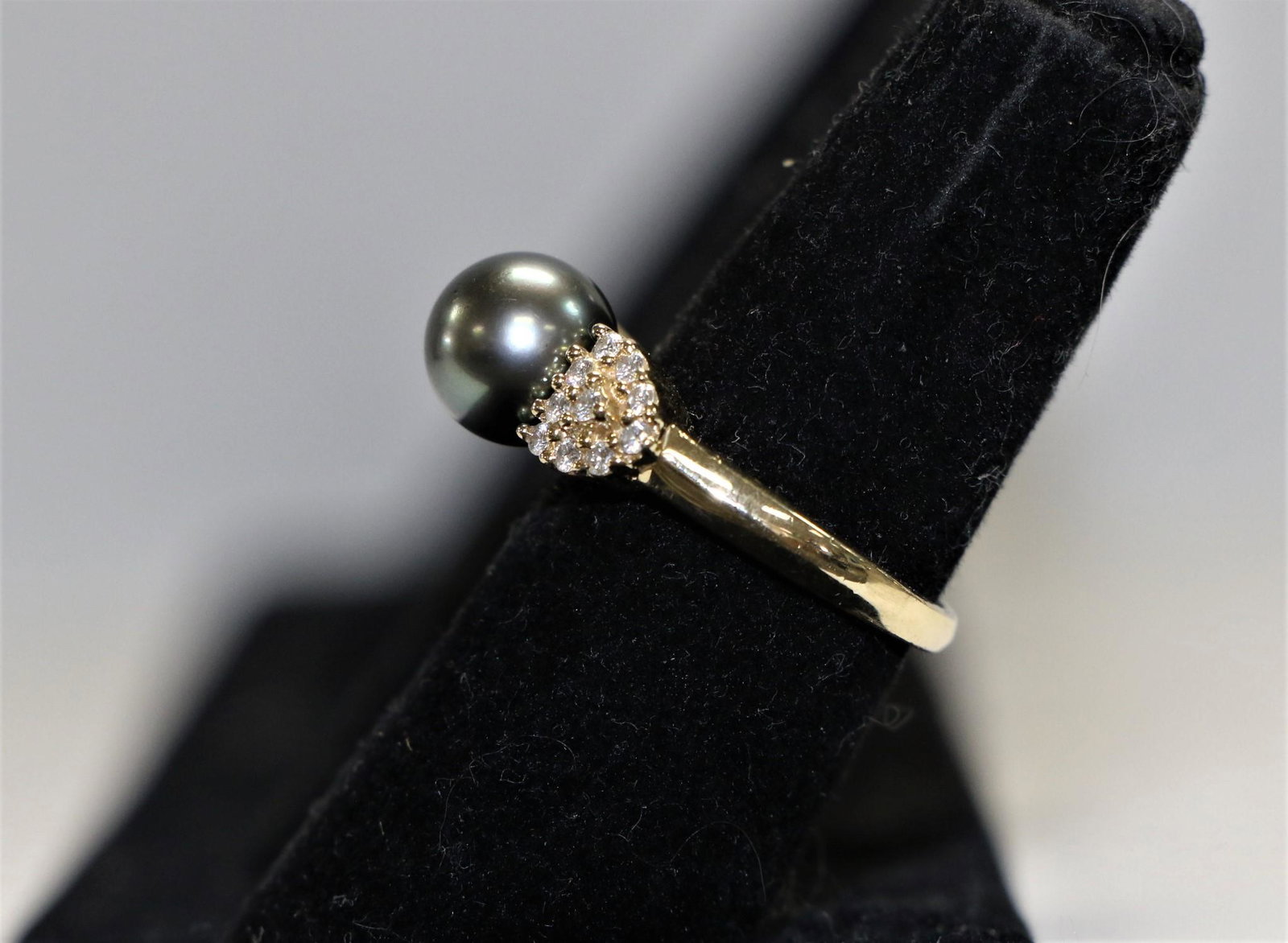 Pearl and Diamond Ring: Pearl and diamond ring; Stamped "14K"; Yellow gold; Total 20 diamonds and one grey black pearl; Pearl measures aproximately 8.8mm; Ring size 7; Total finished weight is approximately 5 grams. See phot