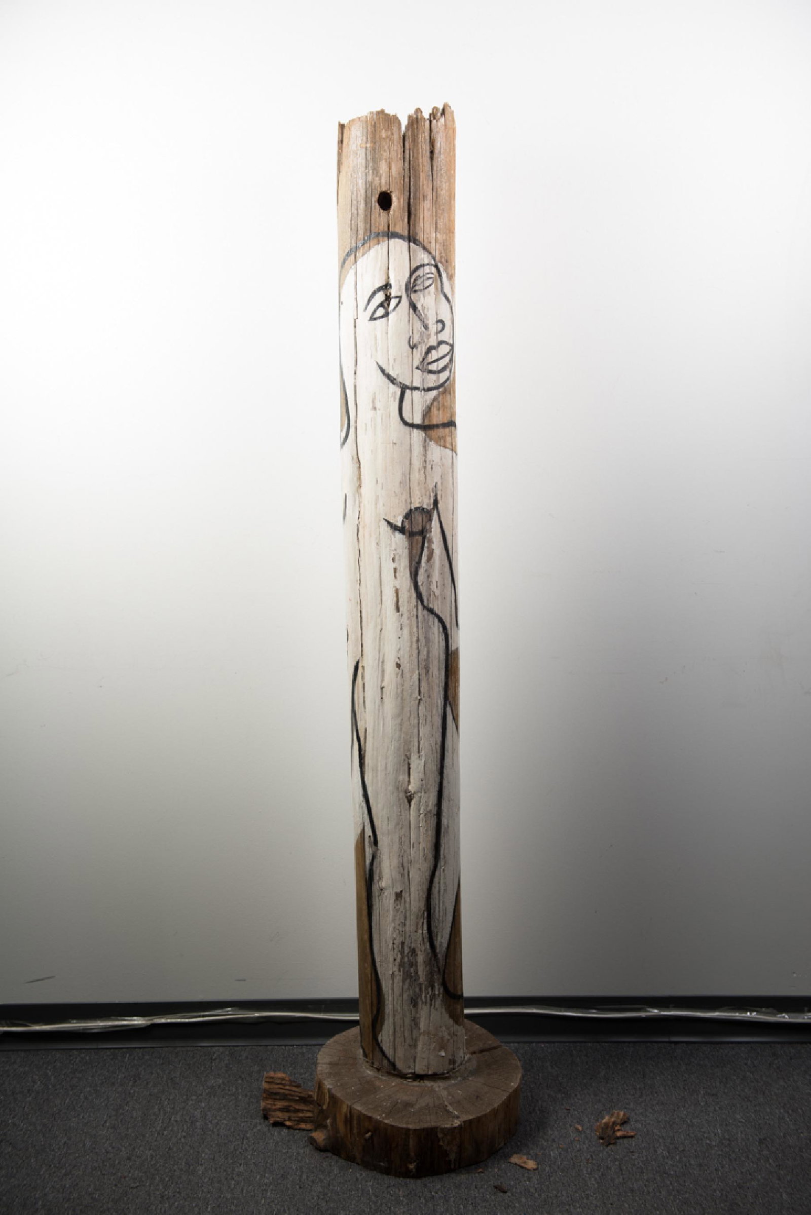 Sarah Ashford, "Pulv People #5" Acrylic on Wood: Sarah Ashford, "Pulv people #5"; Acrylic on wooden telephone pole; 1990; statue measures approximately H 73 inches x D 8.5 inches; Base is a tree slab measuring approximately H 4 inches x Dc 12 inches