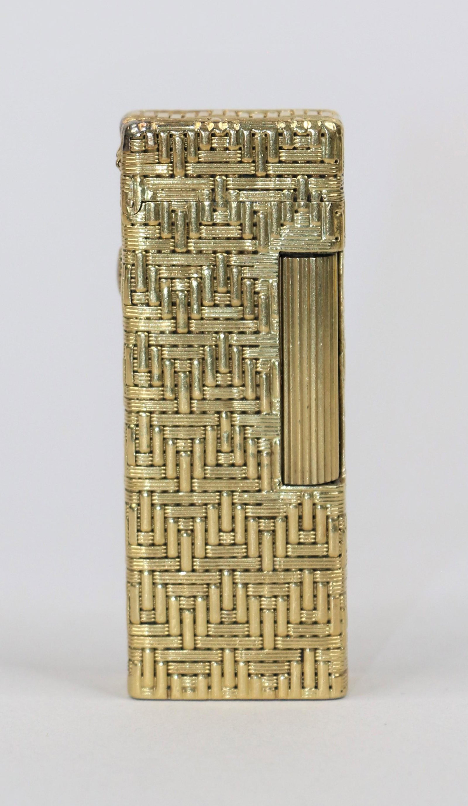 Gold Roller Lighter: Gold roller lighter with basketweave textured surface; Bottom of lighter is marked "18K"; Also marked "USA Pat. No. 1657352"; Measures approximately H 2 1/2 x W 1 x D 1/2 inches; Total weight is appro