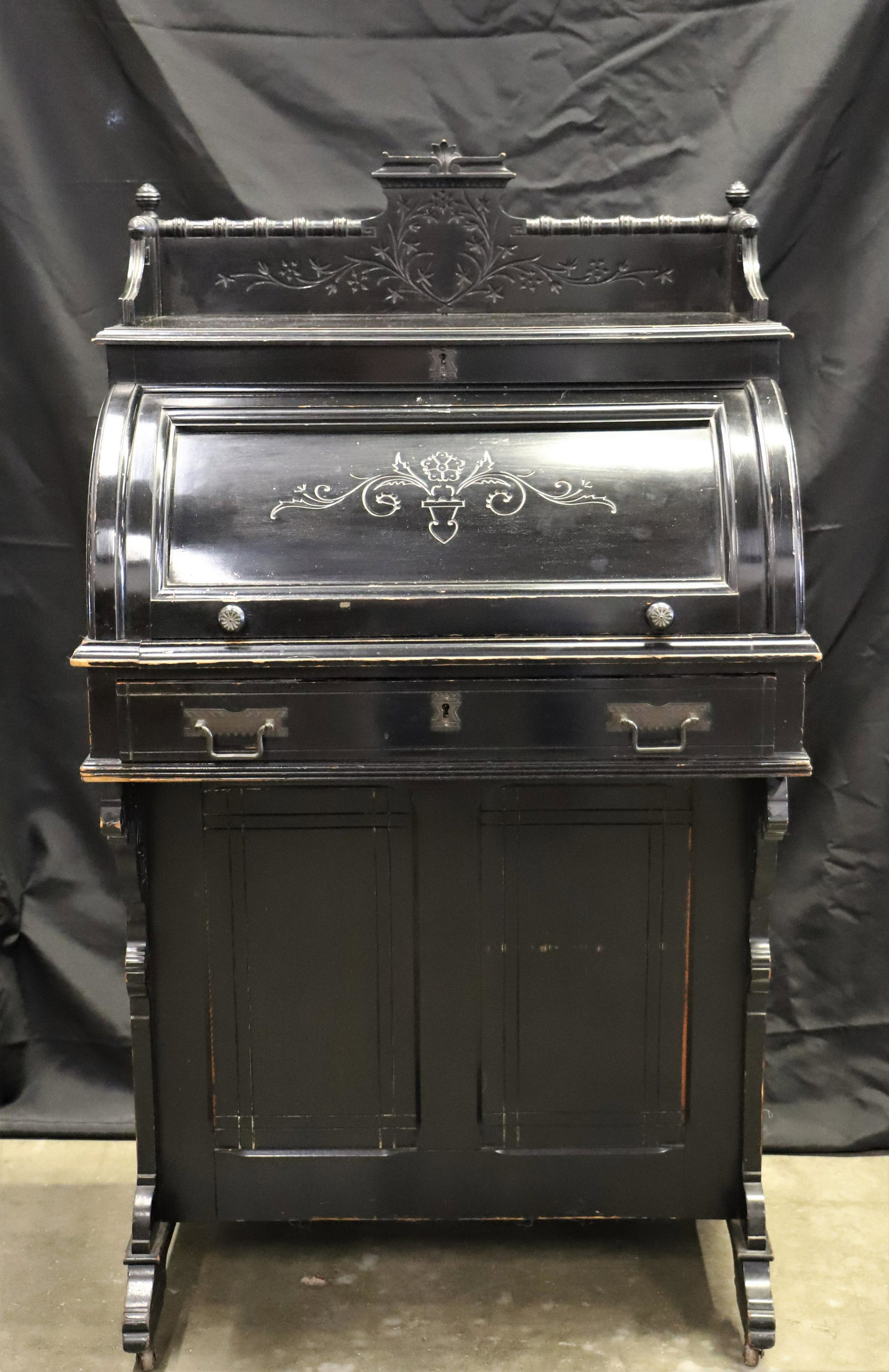 Cylinder Top Davenport Desk: Davenport writing desk with cylinder roll-top; Side panel has locking cabinet; Desk sits on four castor wheels; Front locking drawer includes key; Decorative carved panther detailing on desk brackets;