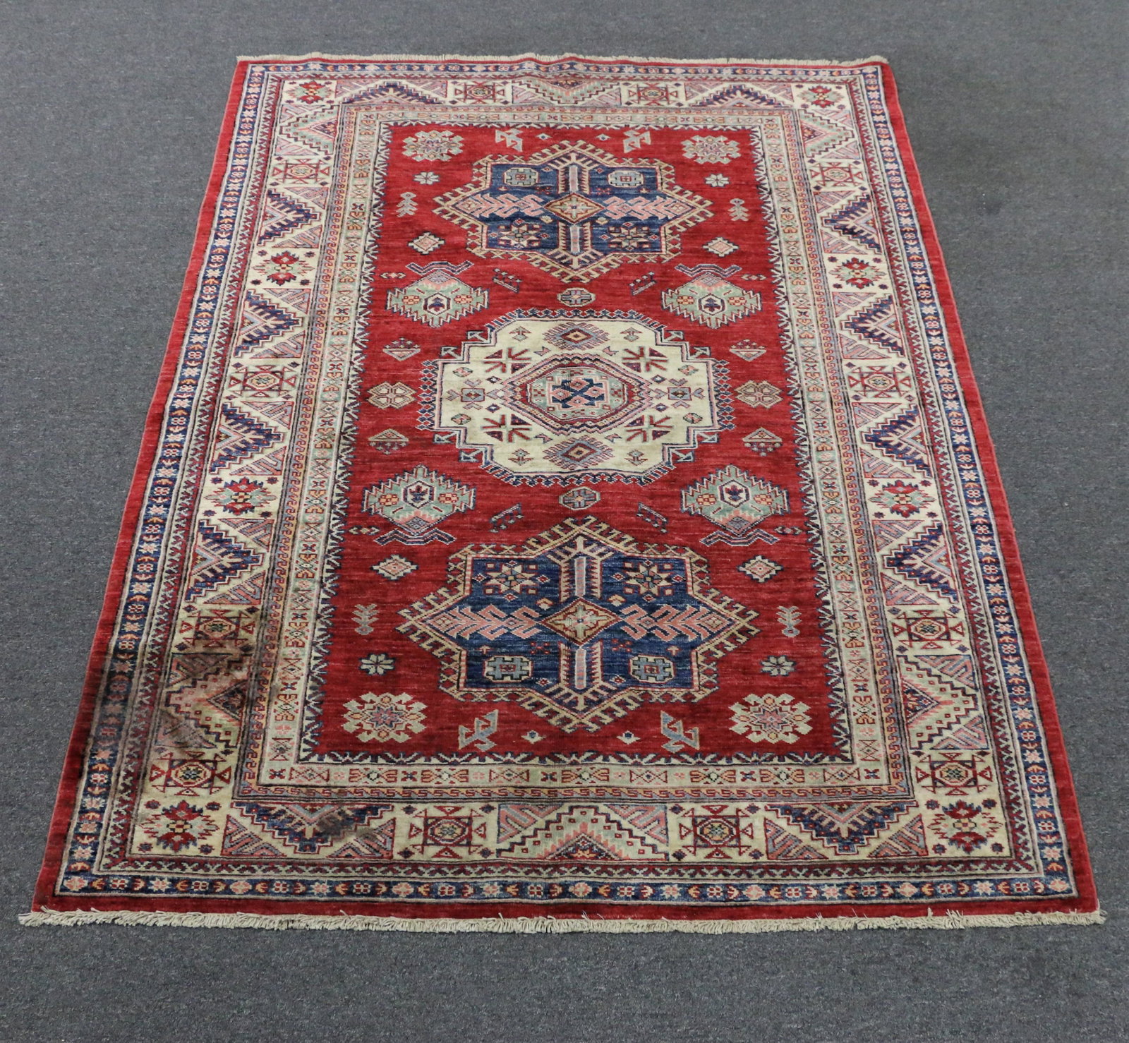 Wool Area Rug: Wool area rug; Measures approximately H 81 x W 60 inches with fringe; Some fading; Stains on one corner. See photos