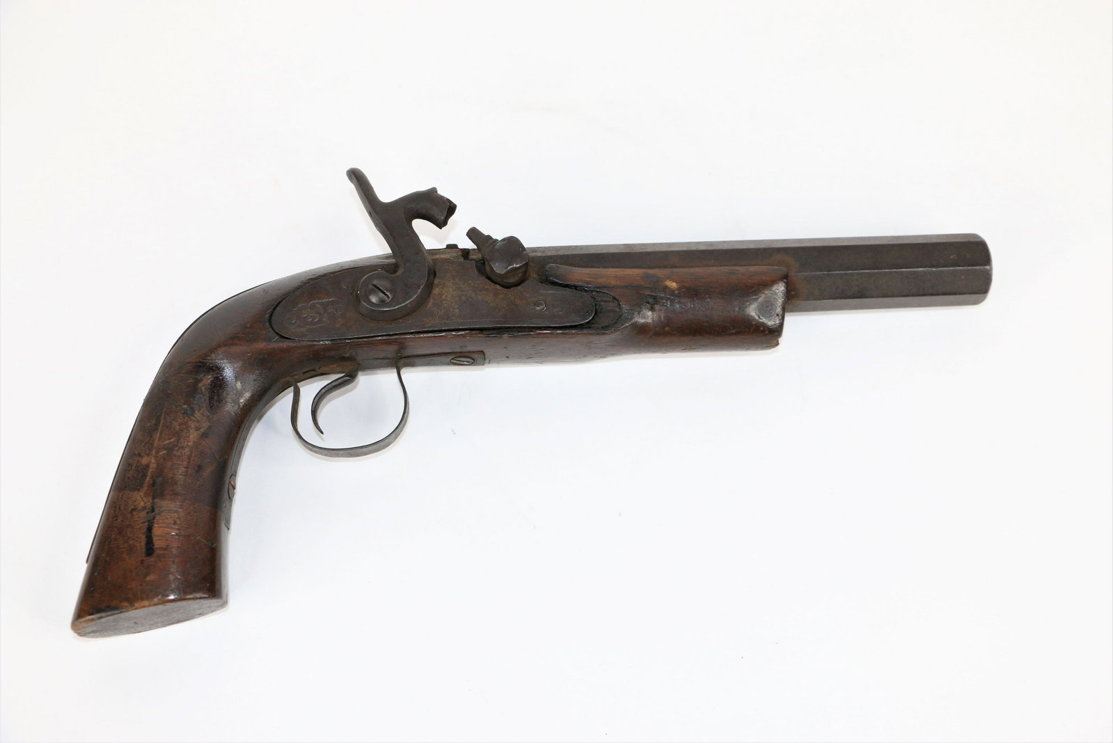 Flintlock Pistol: Wood and metal flintlock; Octagonal barrel; "57" scratched on barrel, no other visible markings; Pressed design work on metal; Measures approximately H 13 x W 2 x D 4 inches; Small nick in wood on bar