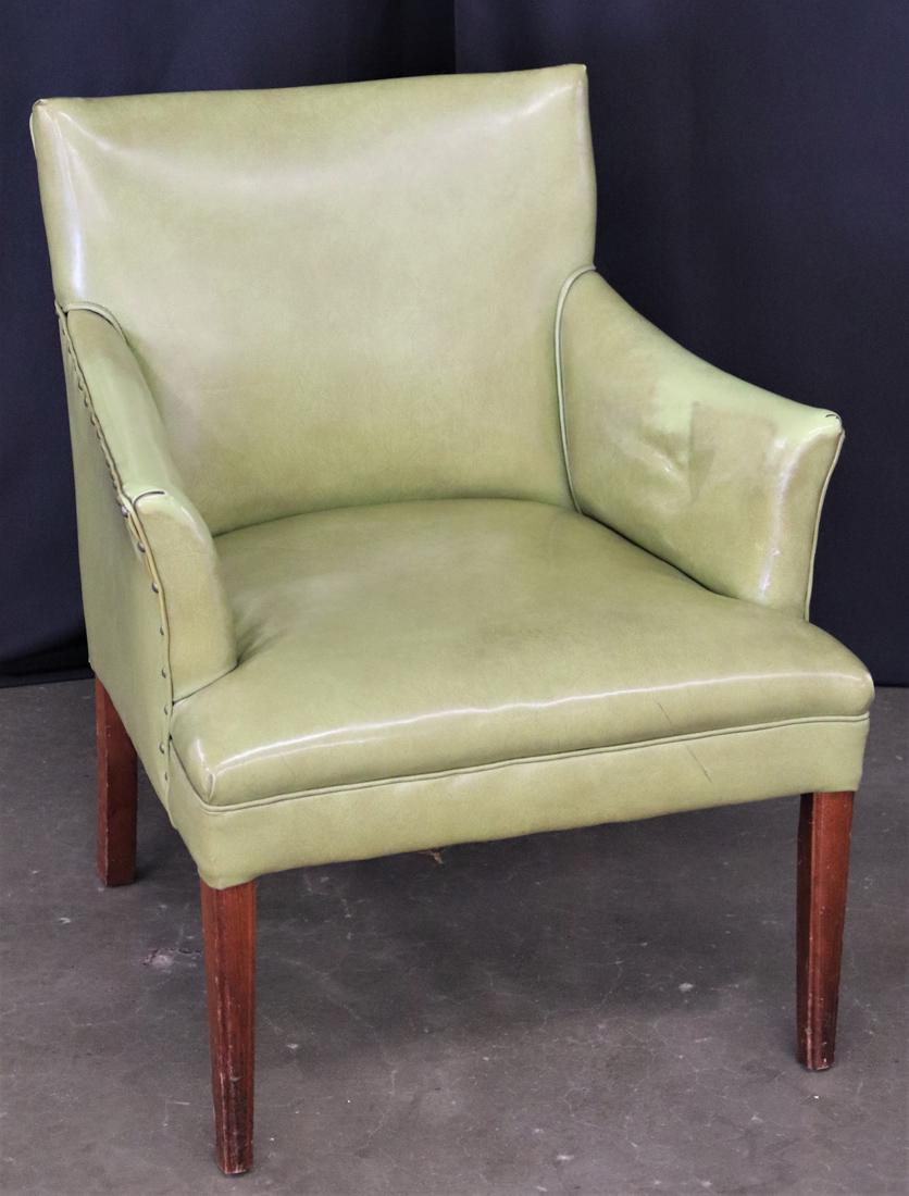 Mid Century Modern Arm Chair: Vinyl and wood arm chair with upholstery tacks on sides; No makers marks; Measures approximately H 31 1/2 x W 24 1/2 x D 25 inches; Discoloration on arms and scratches on wood legs; Rip in bottom lini