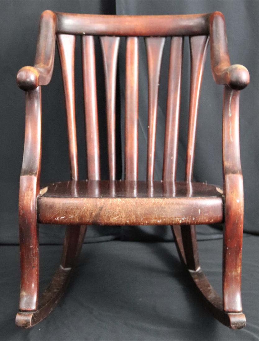 Wood Rocking Chair: Well used wooden rocking chair; No makers mark observed; Measures approximately H 32 3/4 x W 22 1/2 x D 32 inches; Veneer on seat is damaged; Arm rests are well worn; Wood on front of seat is very scr