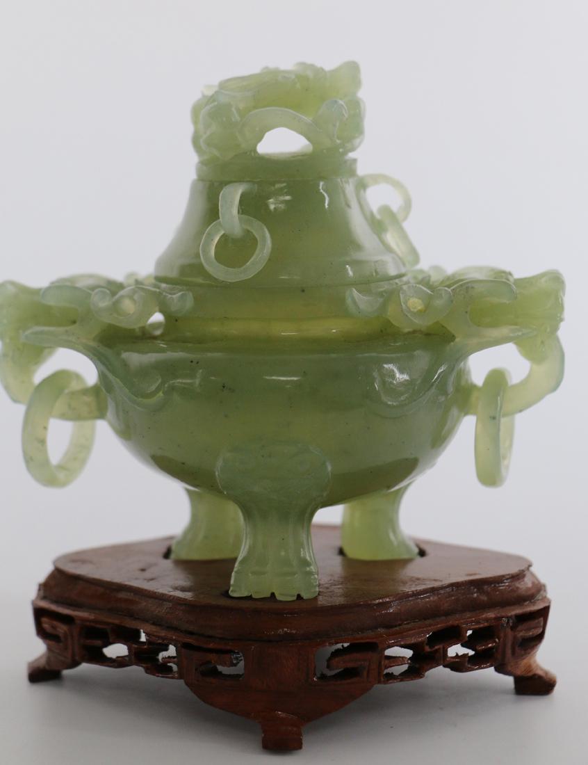 Jade Carving: Carved jade footed jar resting on a wooden base; Jar has dragon handles and a cricket carved on the lid; No maker mark observed; Measures approximately H 5 x W 4 1/2 x D 3 1/4 inches including base; N