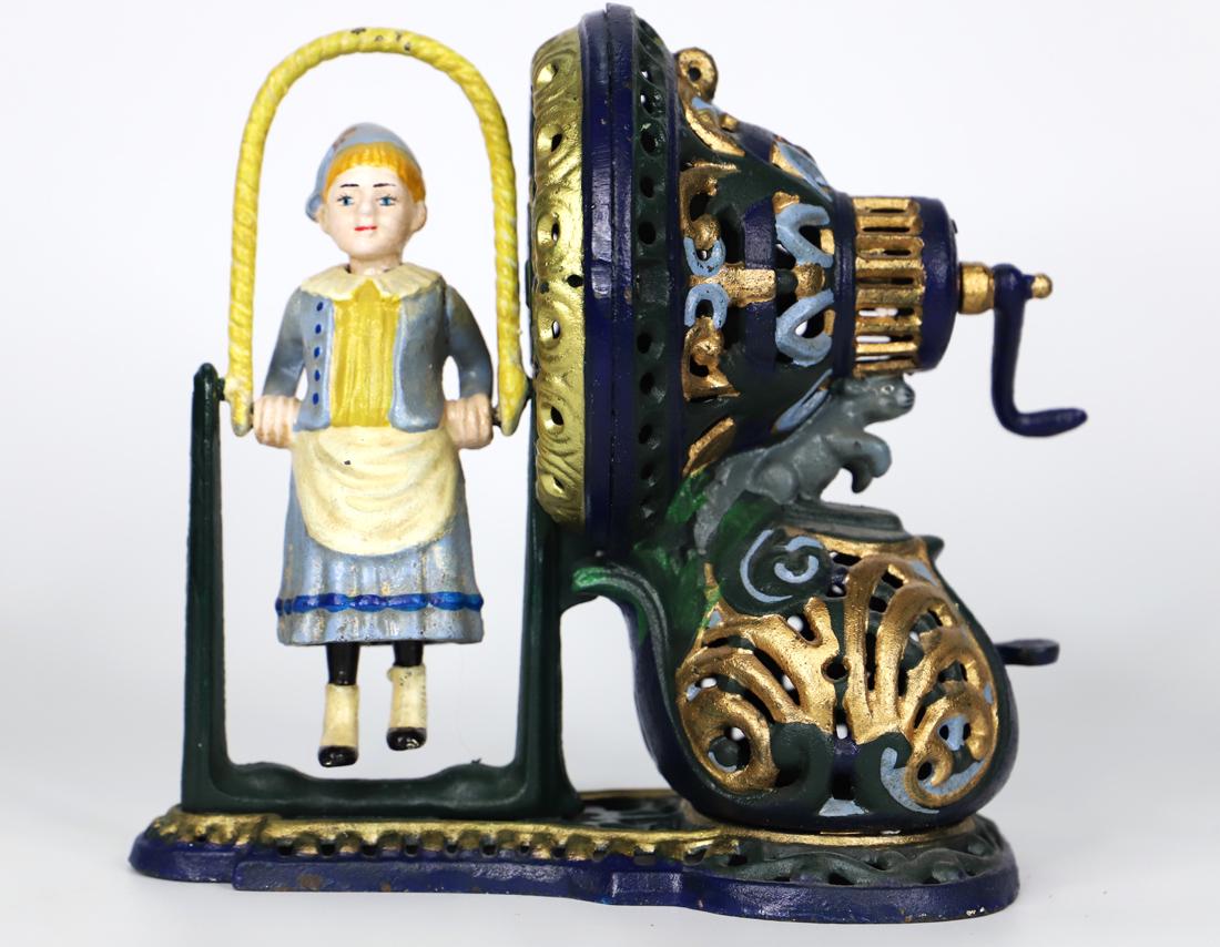 Cast Iron Coin Bank: Vintage Girl Jumping Rope coin bank; No maker mark visible; Measures approximately H 8 1/2 x W 8 1/2 x D 5 1/5 inches; Working condition unknown. See photos