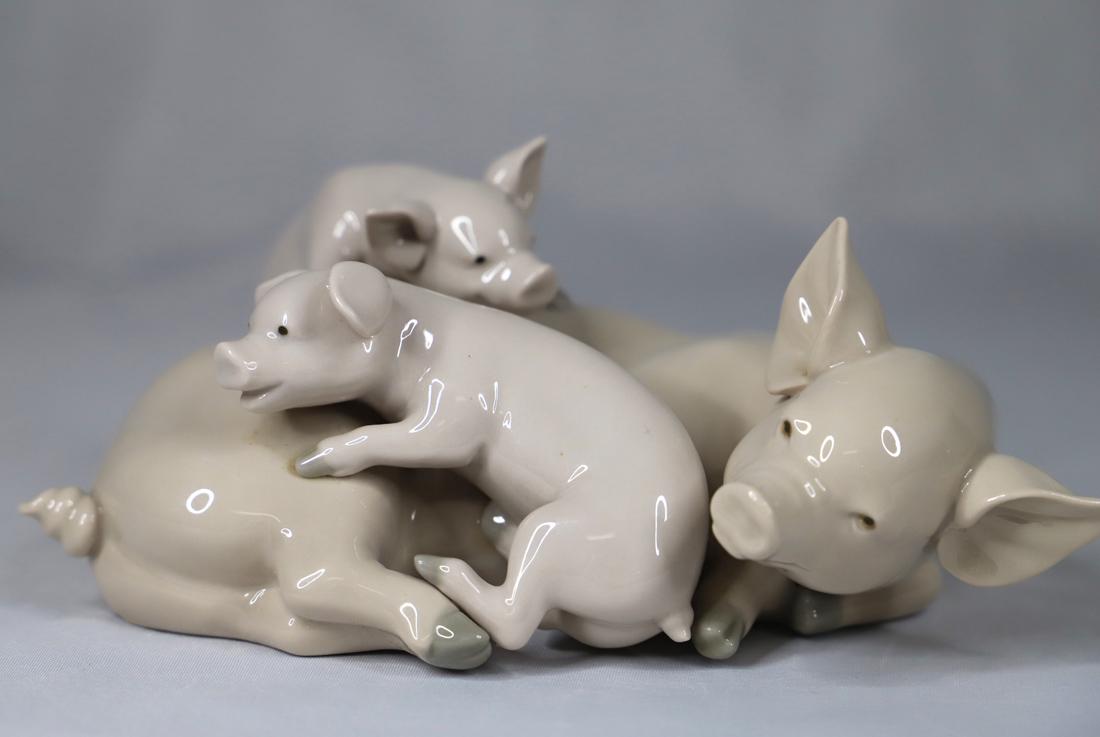 Lladro, Figurine: Porcelain figurine titled "Playful Piglets"; Bottom is marked "Lladro, Handmade in Spain"; Measures approximately H 2 3/4 x W 7 x D 4 1/2 inches; No damages observed; Some minor dust residue. See phot