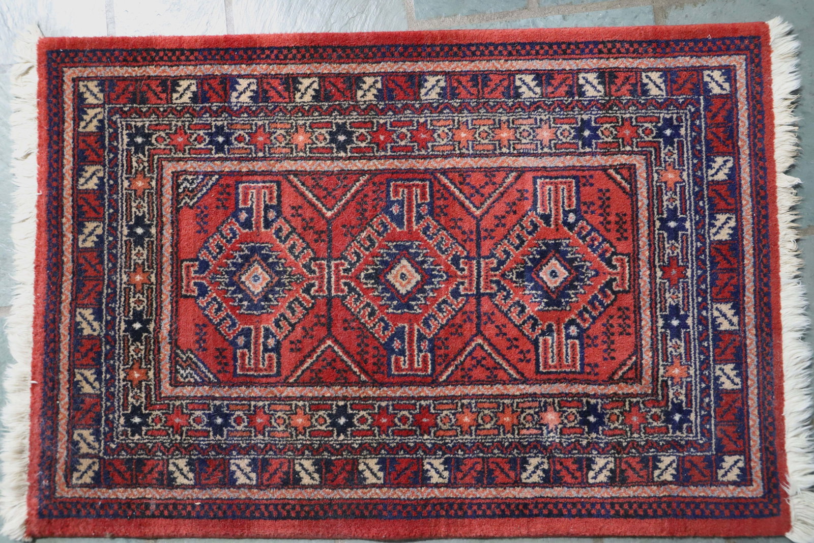 Area Rug: Small carpet with fringe; Possible wool; Measures approximately (with fringe) H 24 x W 37 1/2 inches; No damage observed; See photos. Pick up in Denver