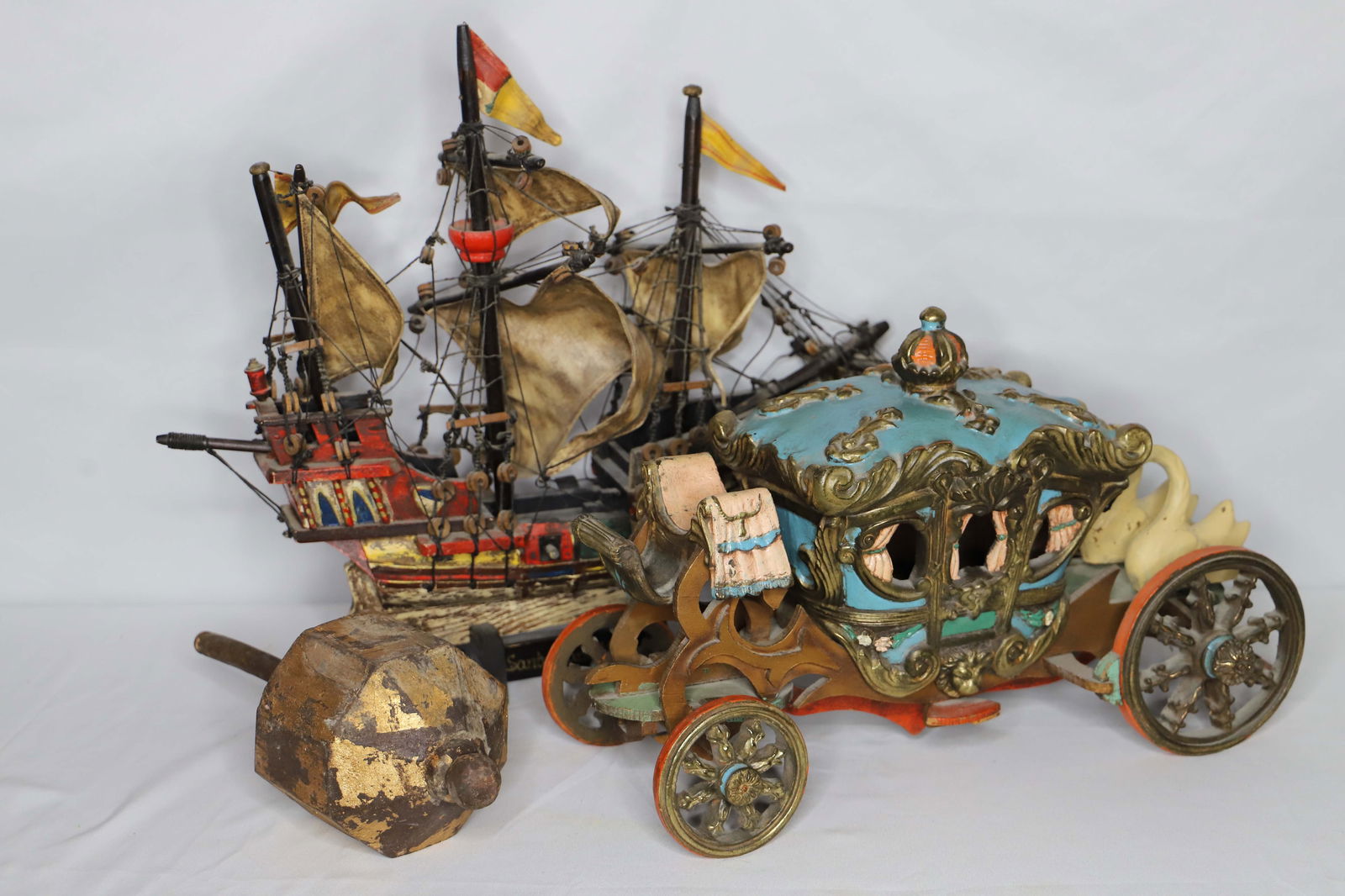 Wood Carriage, Ship: Model ship of the Santa Maria; Metal and wood coach; Possibly a wood and gold gilt Buddhist wheel; No maker marks observed; Ship measures approximately H 18 x W 12 x D 5 inches; Paint is worn; Items a