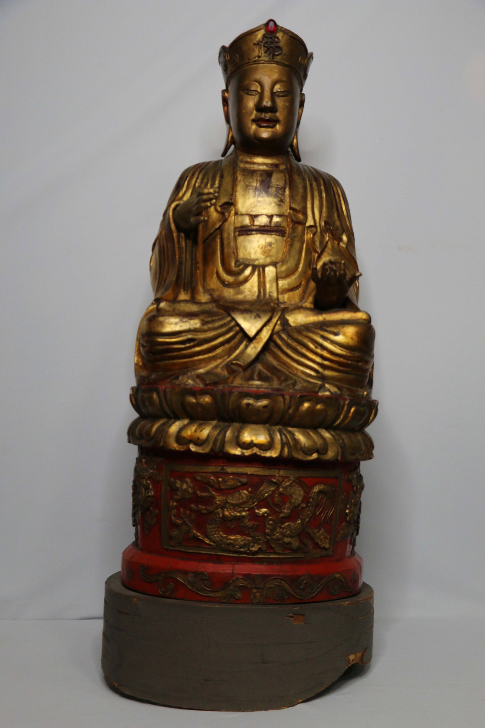 Chinese Buddha: Lacquered wood carved Buddha painted red and gold; No maker marks observed; Mounted on a wood stand; Possibly late Ching Dynasty; Measures approximately H 33 x W 14 x D 11 inches; Cracking in the wood
