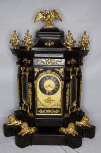 French Bracket Clock: Ebonised wood and ormolu clock with an eagle on the top; Pendulum is marked "France" and numbers written inside bell; No other marks observed; Clock sits on the lion stand; Measures approximately H 26