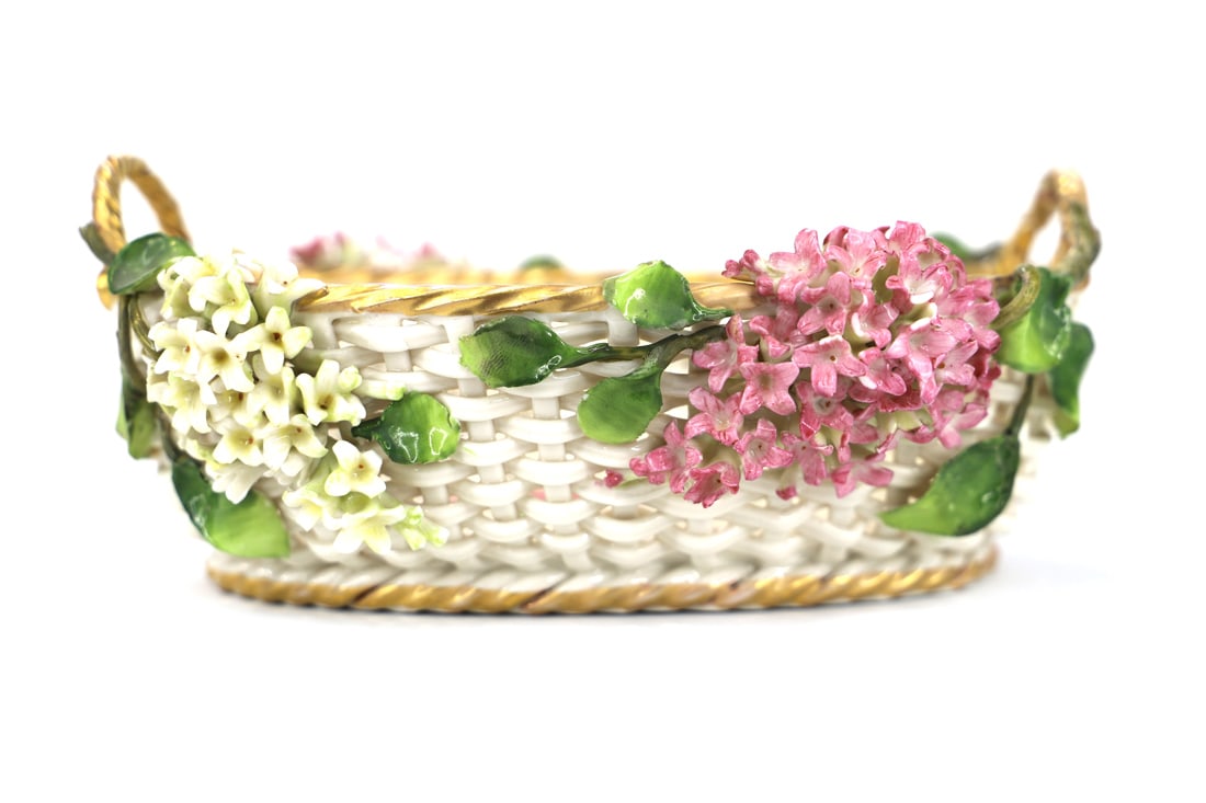 Von Schierholz, Porcelain Basket: Vintage woven porcelain basket with flowers; Maker mark is on the base; Measures approximately H 3 x W 7 1/4 x D 5 1/5 inches; One handle is broken; Gold paint shows wear. See photos