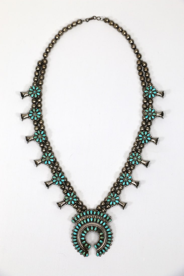Sterling, Squash Blossom Necklace: Turquoise and sterling silver Native American squash blossom necklace; Necklace is signed "T.A." on upper back top of blossom, and stamped "Sterling"; Drop measure is 14 1/2 inches; One turquoise inse