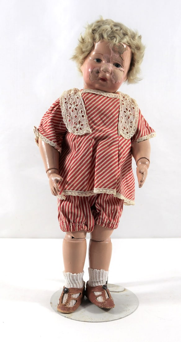 Schoenhut, Doll: One Schoenhut doll with red and white striped shorts and top; Stand included; Eyes are painted, all fingers present; Hinged wooden body; Doll stands approximately H 14 inches; Peeling and cracking on