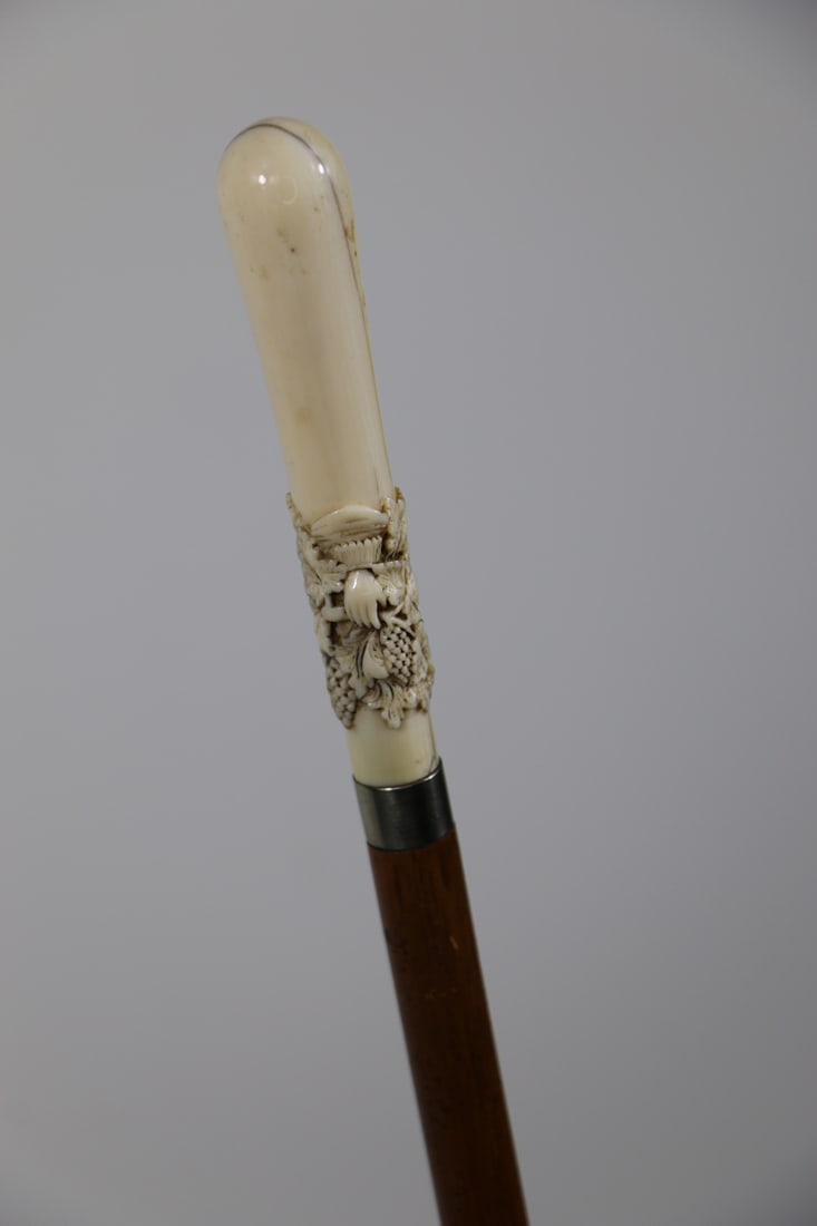 Bone Handled Cane: Antique bone handled women's cane; Carved handle depicts a lady's hand and wrist among grape vines; Steel and brass tip; Measures approximately H 34 inches; Bone handle has old crack, tip is tarnished