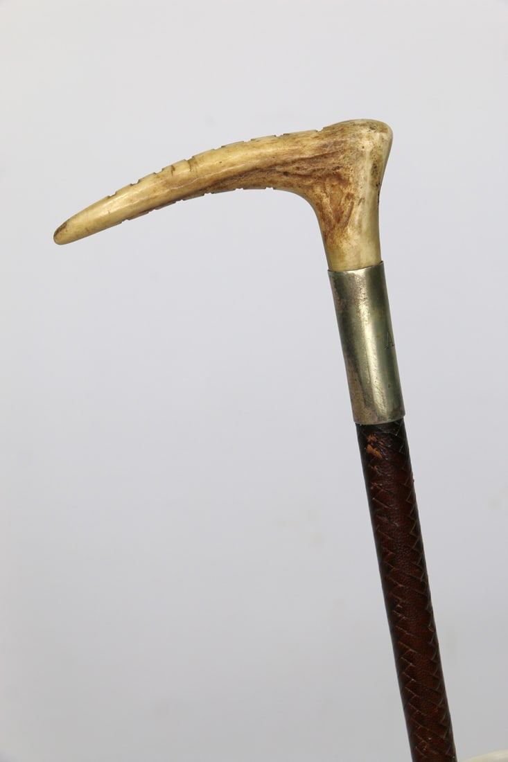 Bone Handled Riding Crop: Antique riding crop with bone handle, sterling silver collar and leather-covered shaft in a herringbone pattern; Collar is carved with initials "A.L.C."; Underside of handle is carved with a series of