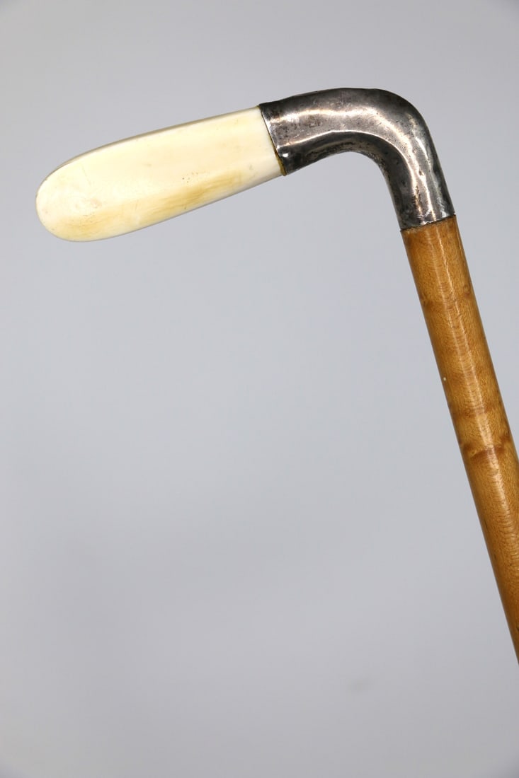 Bone Handled Cane: Antique walking stick with bone handle, sterling silver collar and wood shaft; Measures approximately H 34 3/4 inches; Silver is tarnished and bone has older cracks; See photos