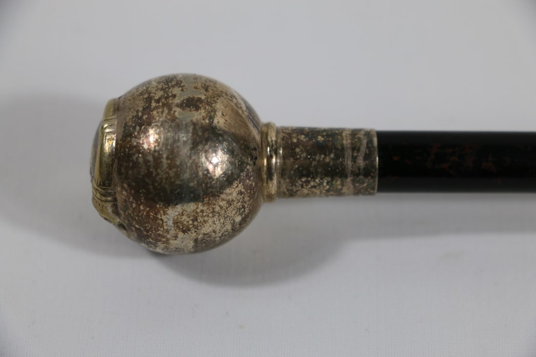 Vintage Cane: Short vintage cane with silver tone handle, wooden shaft and silver tone ferrule; Motif of horn and bow on top of handle; Measures approximately L 27 inches; Metal parts exhibit tarnish, and wear comm
