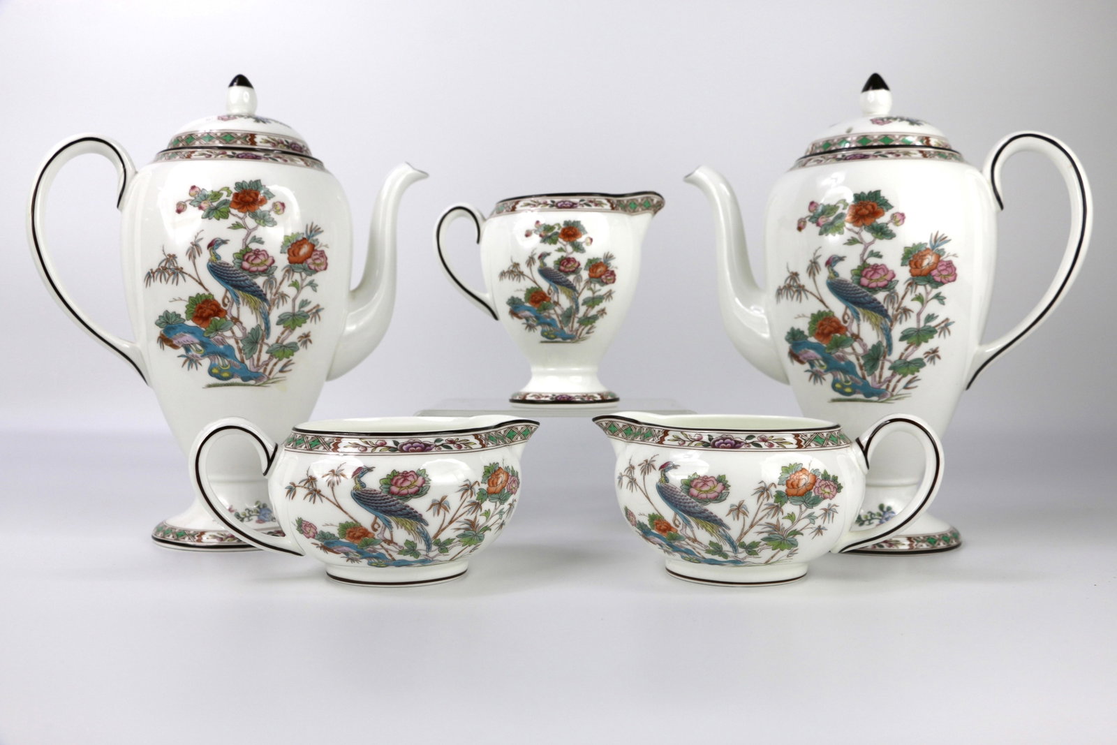 Wedgwood, Chocolate Pots, Creamers: Two coffee / chocolate pots, three creamers in various shapes and sizes; All in the Kutani Crane pattern; Number R4464Hot chocolate pot measures approximately H 9 x W 7 1/2 x D 4 inches; In used condi