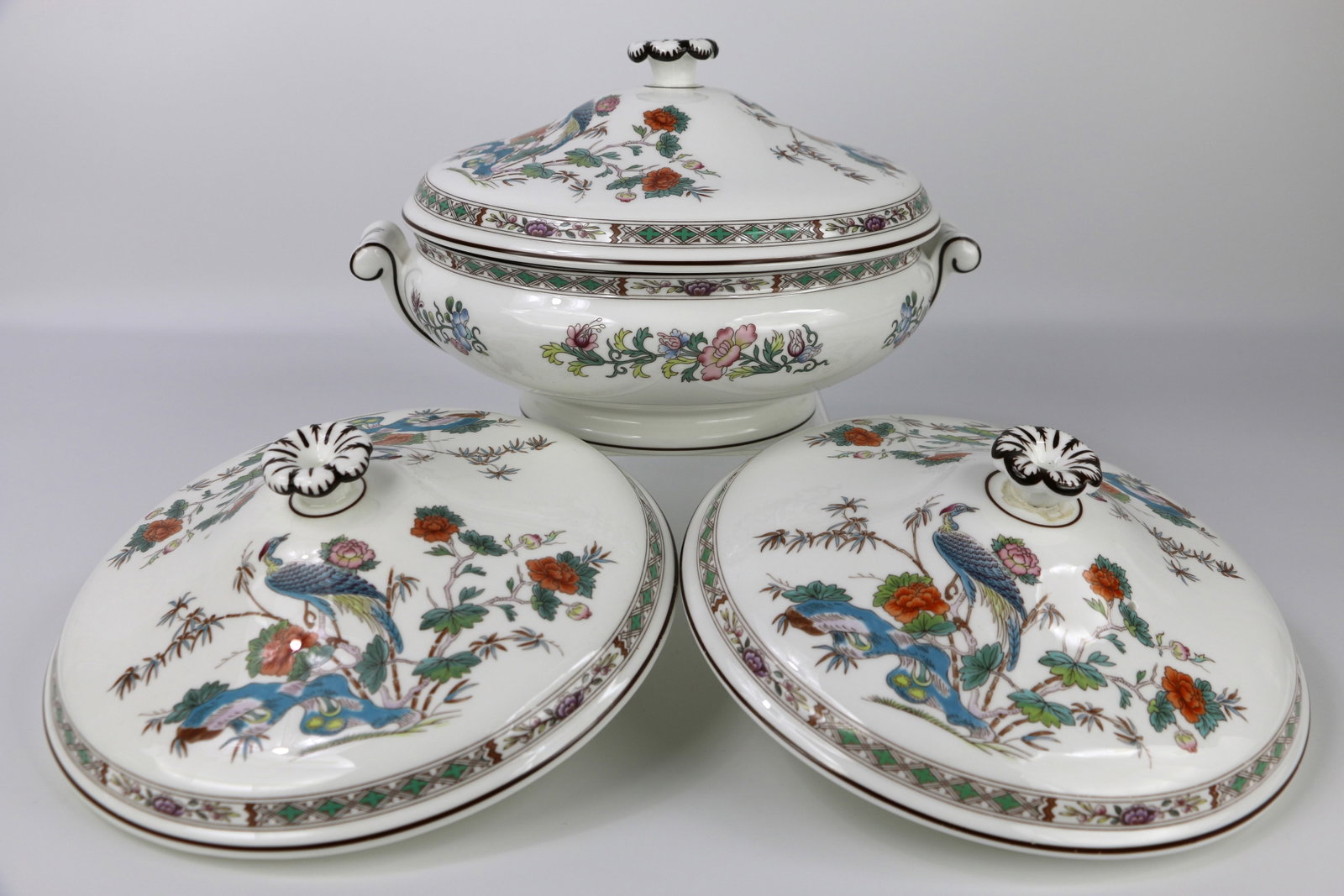 Wedgwood, Covered Casserole: One covered casserole and two extra lids that fit the bowl; In the Kutani Crane pattern; Number R4464; With lid on, serving bowl measures approximately H 6 x W 10 x D 8 inches; One lid has a crack; On
