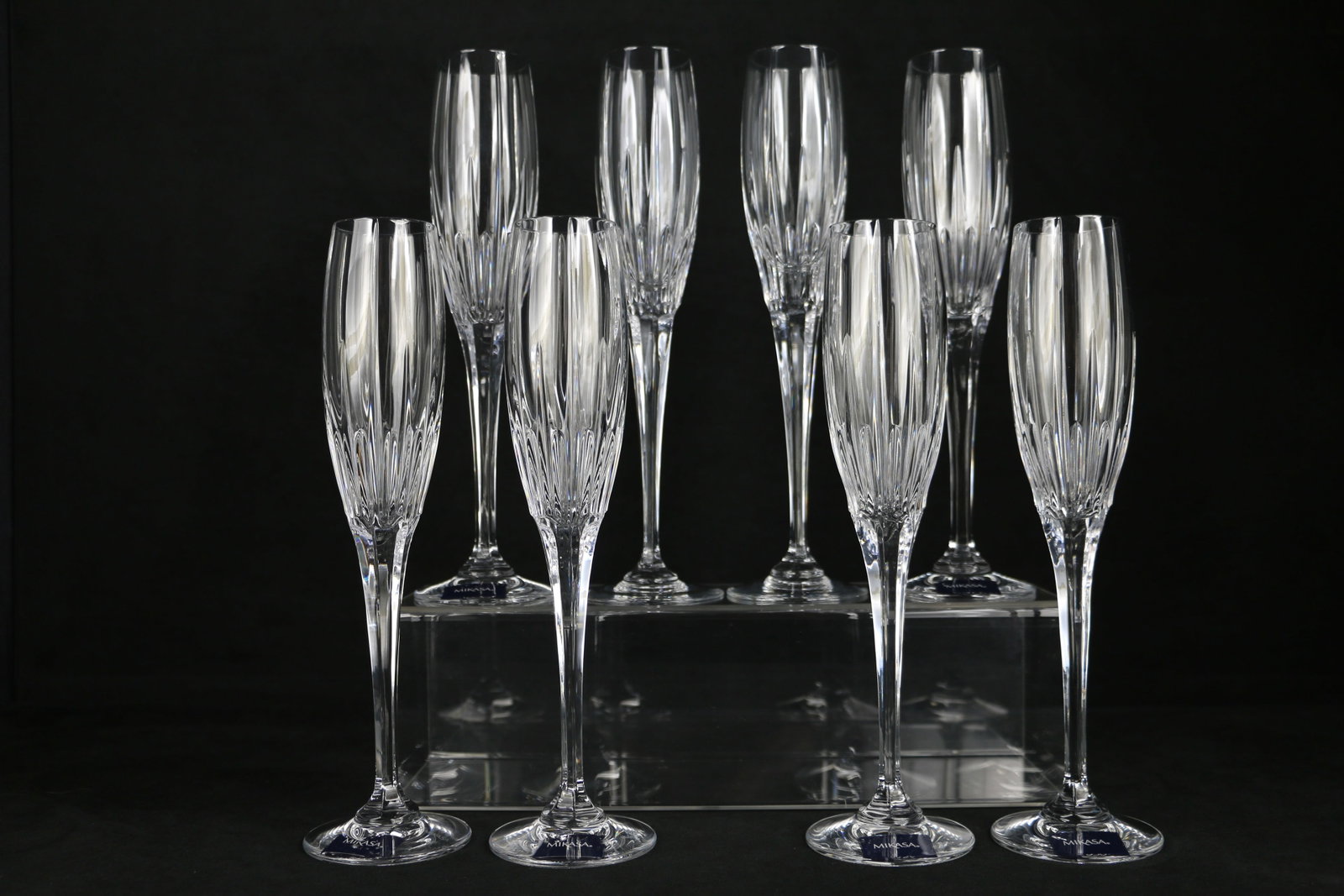 Mikasa, Champagne Flutes: Eight Mikasa crystal glasses in the "Arctic Lights" pattern; Each glass measures approximately H 10 1/2 inches; One glass has small chip on bottom rim; See photos