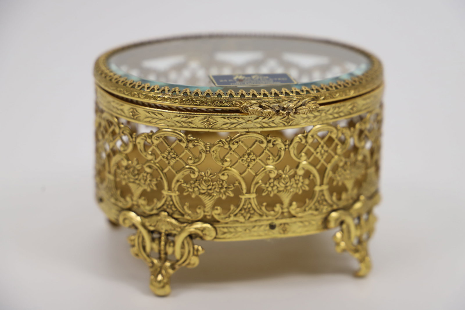 Matson, Jewelry Casket: Ormolu filigree jewelry box with beveled glass lid; No maker mark observed; Measures approximately H 3 x W 4 1/4 x D 4 inches; No damage observed. See photos