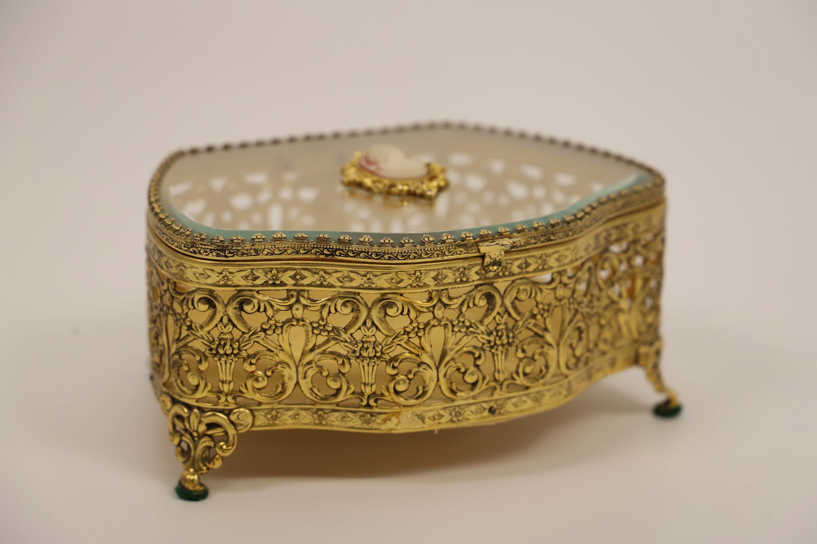 Vintage Jewelry Casket: Ormolu filigree jewelry box with beveled glass lid; Cameo on lid; No maker mark observed; Measures approximately H 3 x W 6 1/4 x D 5 1/2 inches; No damage observed. See photos
