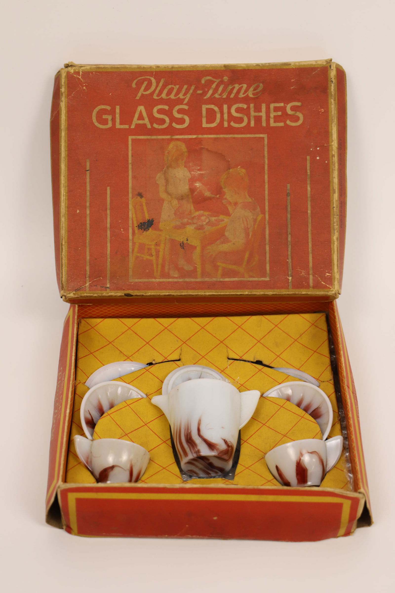 Akro Agate Co., Tea Set: Vintage child's Play-Time Glass Dishes; Number 1020 Maroon tea set; In original box; Box measures approximately H 2 1/2 x W 9 x D 7 1/2 inches; box is damaged. See photos