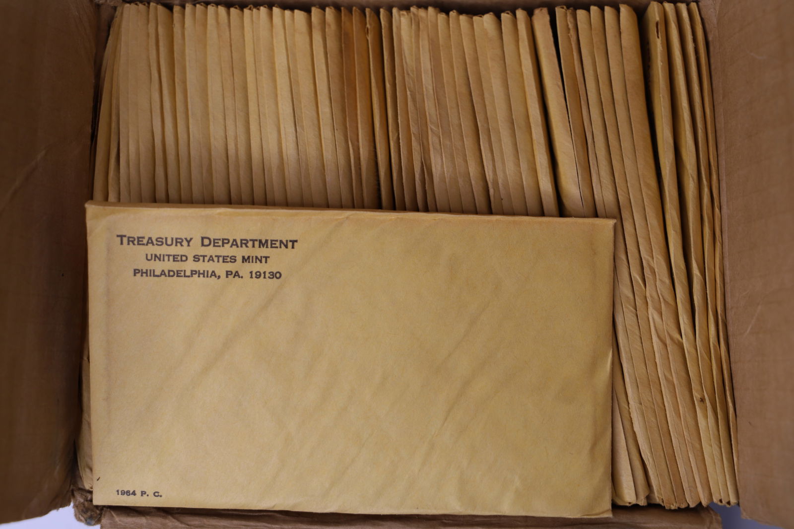 50 Sets of 1964 US Proof Coins: Fifty sets of 1964 US mint coins; Each contains one half dollar, quarter, dime, nickel, penny; Forty-nine sets are sealed in the original envelopes and all are in the original mailing box from the US