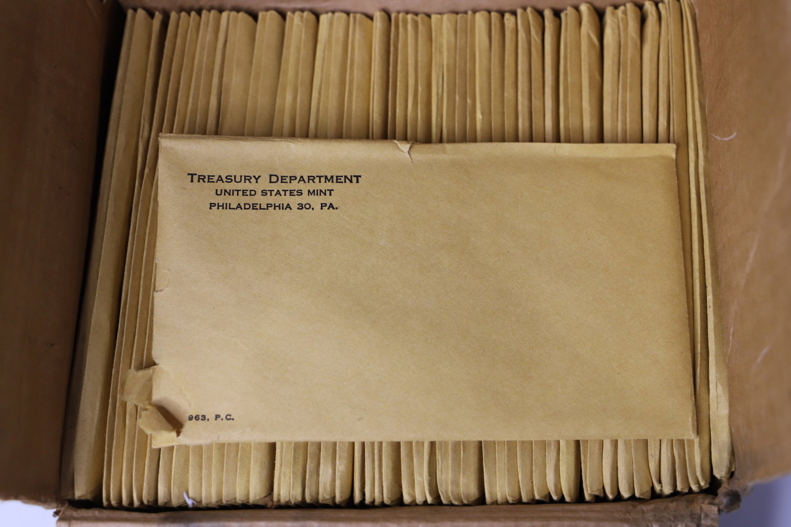 50 Sets of 1963 US Proof Coins: Fifty sets of 1963 US mint coins; Each envelope contains one half dollar, quarter, dime, nickel, penny; Forty-nine sets are sealed in the original envelopes and all are in the original mailing box fro