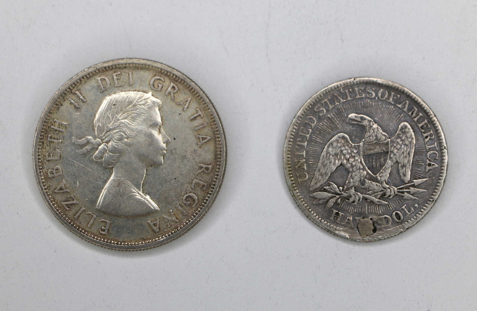 Canadian, US Silver Coins: One Canadian dollar coin, 0.80 pure silver, dated 1959; One United States silver half dollar, dated 1853; Both have been circulated. See photos