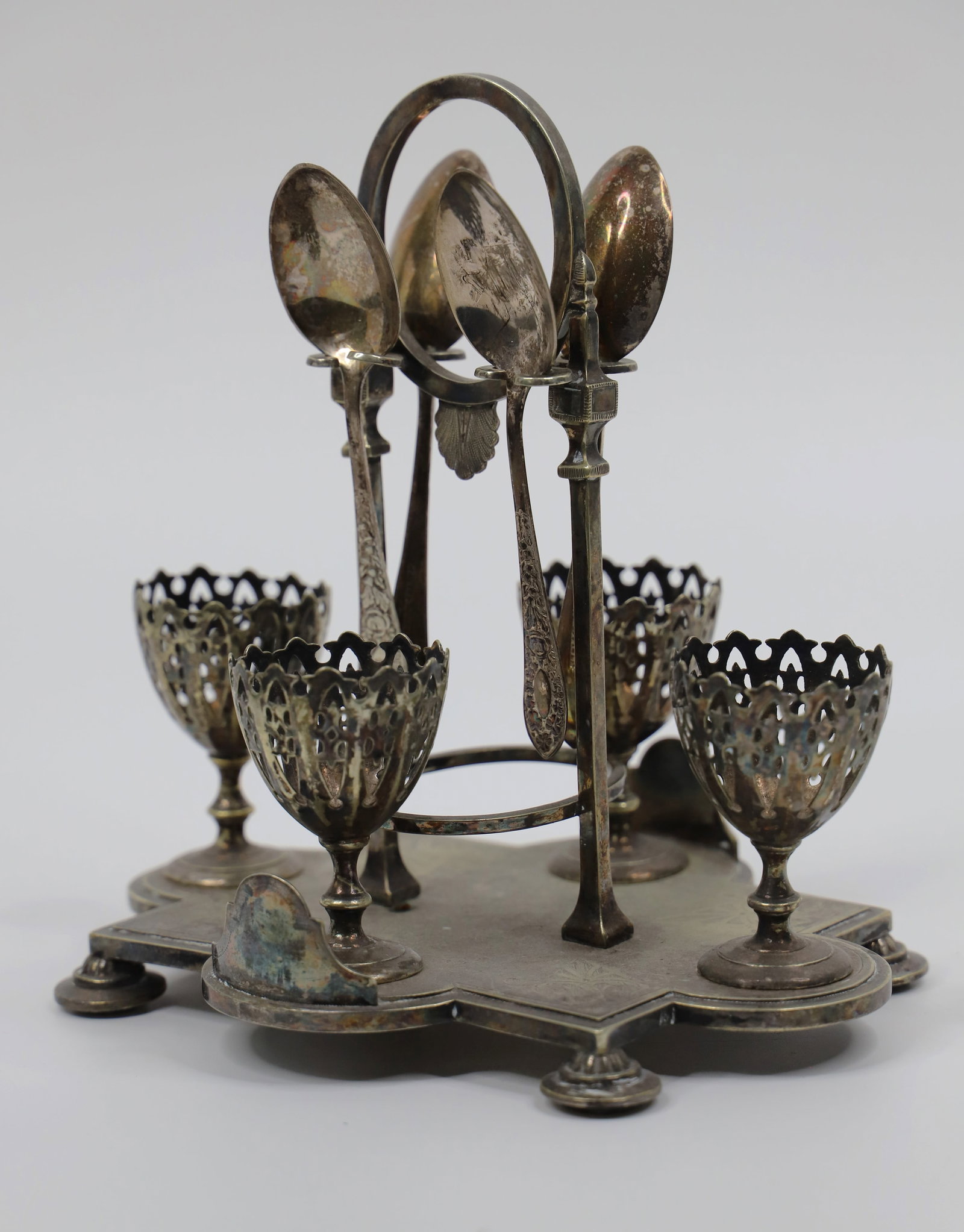 Vintage Egg Cup Cruet: Silverplate, four cup egg caddy; Spoons are marked "Potter Sheffield"; Measures approximately H 7 1/4 x W 7 1/2 x D 6 inches; All are tarnished, dented and scratched. See photos