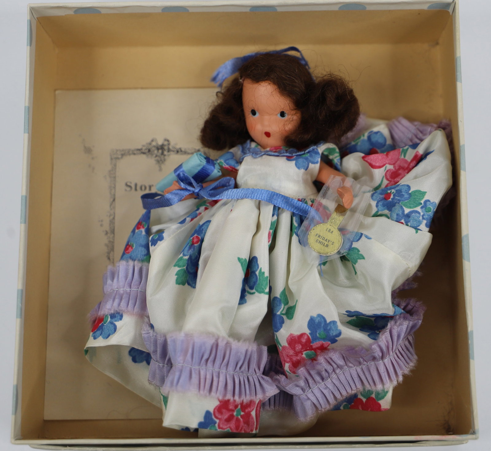 Nancy Ann Storybook Doll: "Friday's Child is Loving & Giving", Number 184; In box with pamphlet; Painted face, jointed arms and legs; Has gold wrist tag; Doll stands approximately H 5 1/4 inches; No damage observed; No guarant