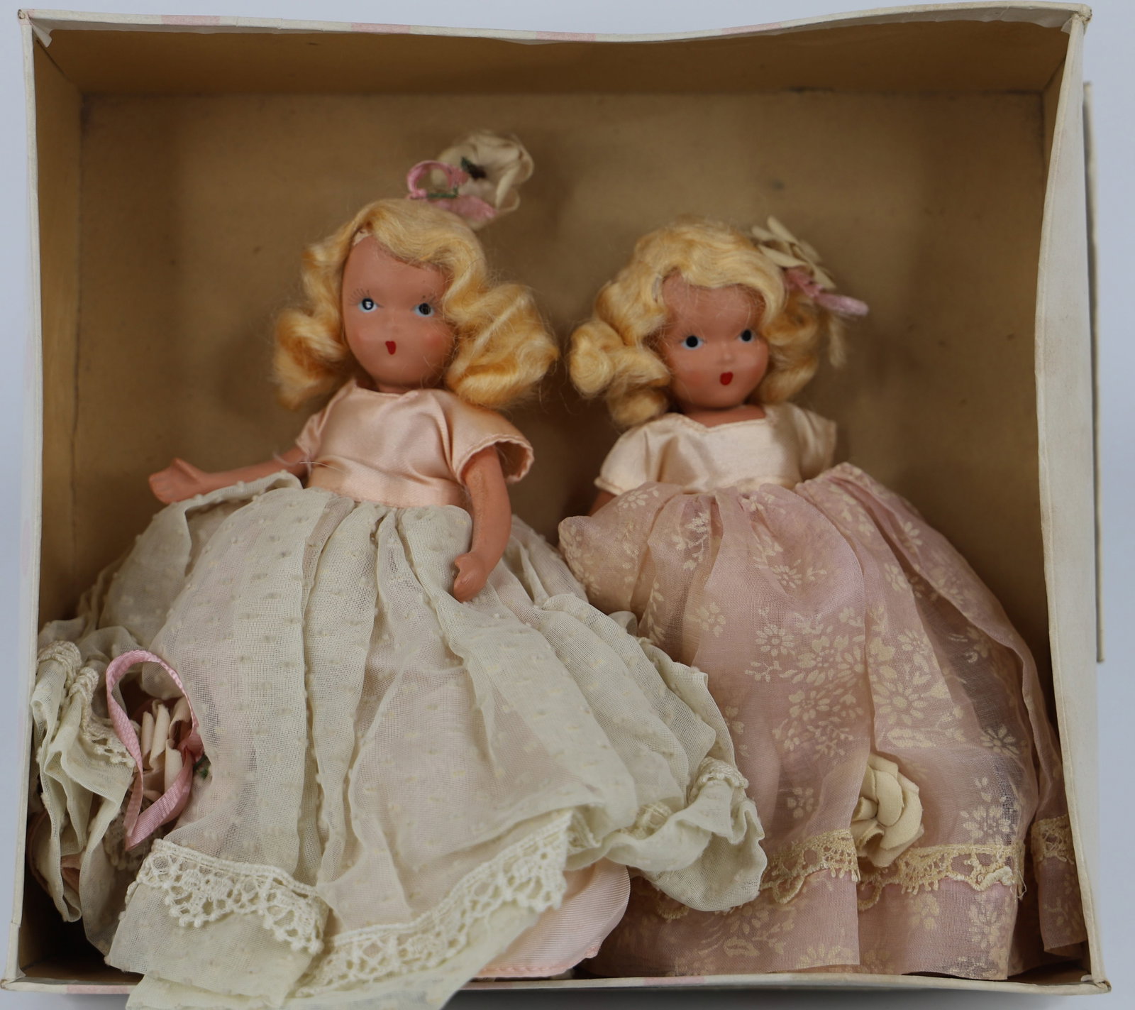 Nancy Ann Storybook Dolls: Two similar dolls in a box marked "A Rosebud Gift to love me thru the June Days'; Number 192; Both have painted faces with jointed arms and legs; Each stands approximately H 6 inches; Heads are loose;